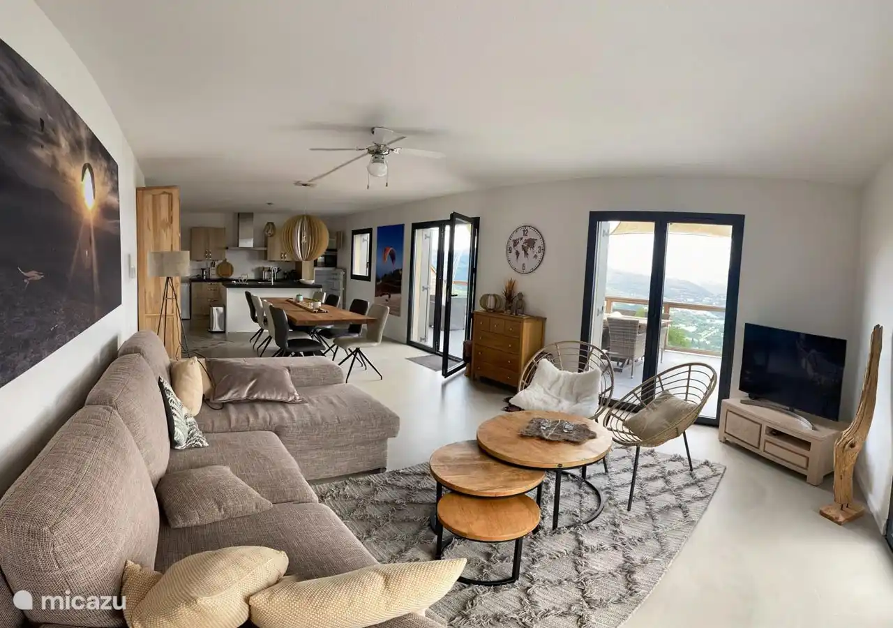 Sala de estar con cómodo sofá y TV de pantalla plana.