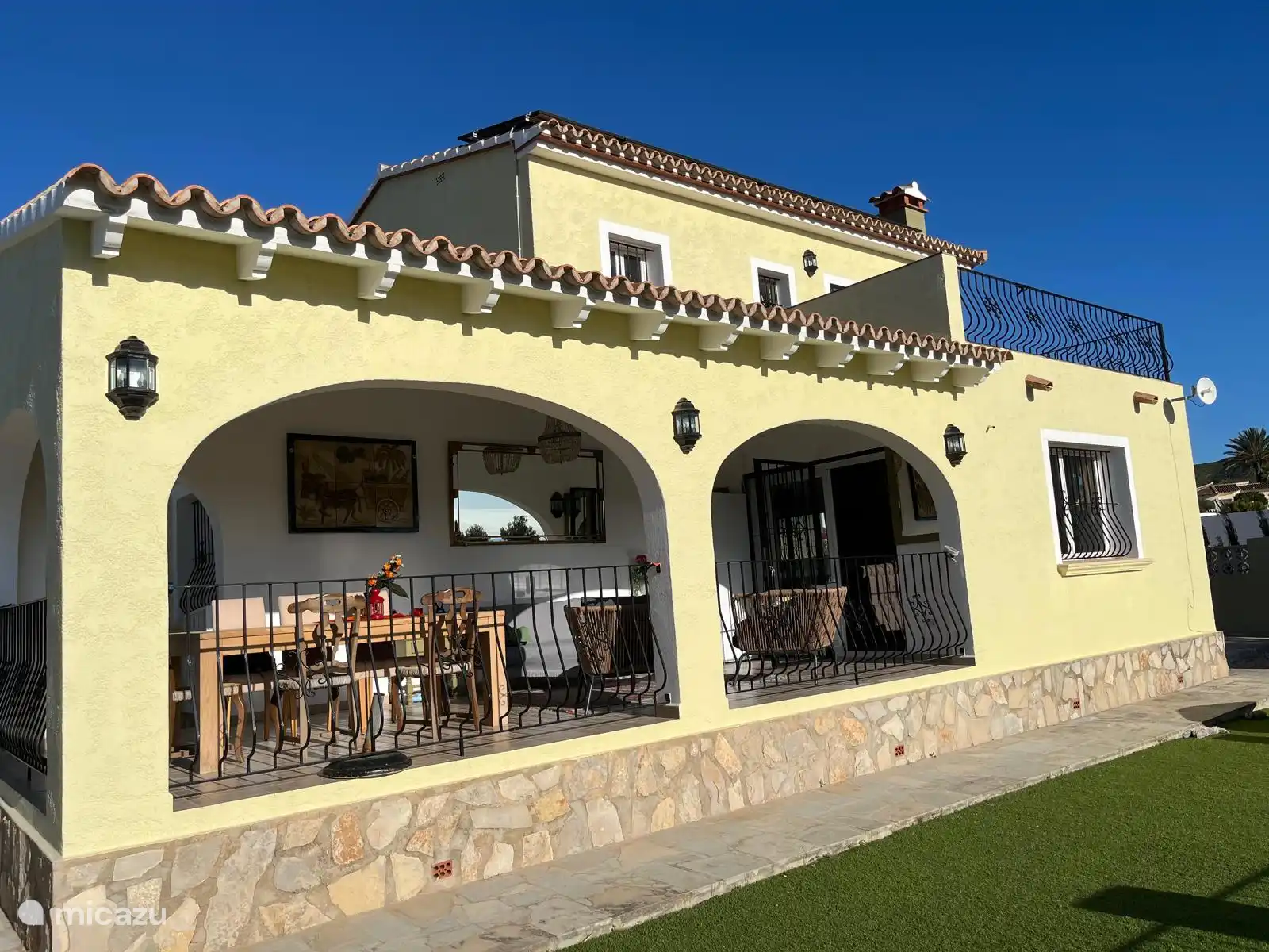 Het terras heeft een zitje en een 6 persoonseettafel.