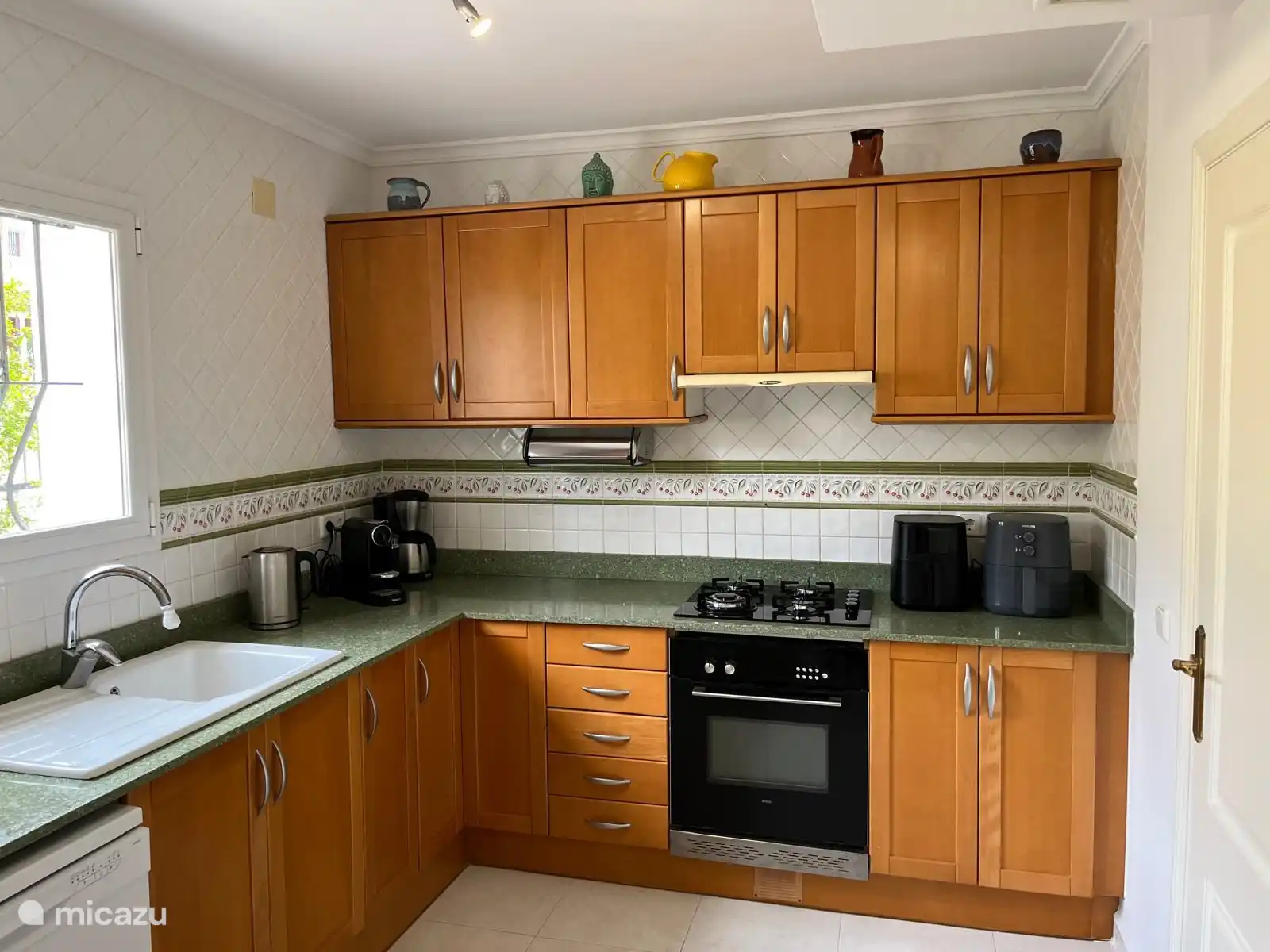 Een fijne keuken met diverse koffiezetapparaten, een airfryer en een goedwerkende oven.