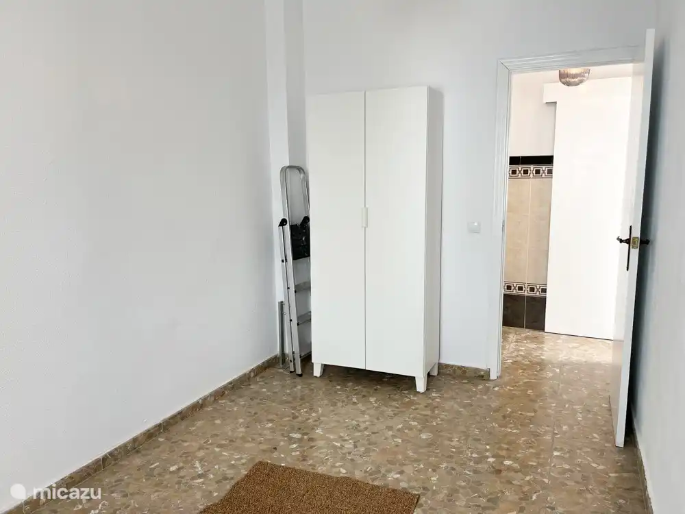 Das zusätzliche Zimmer neben dem Flur. Durch diesen Raum gehst du zu Schlafzimmer 2. Im Extraraum befindet sich ein Kleiderschrank.