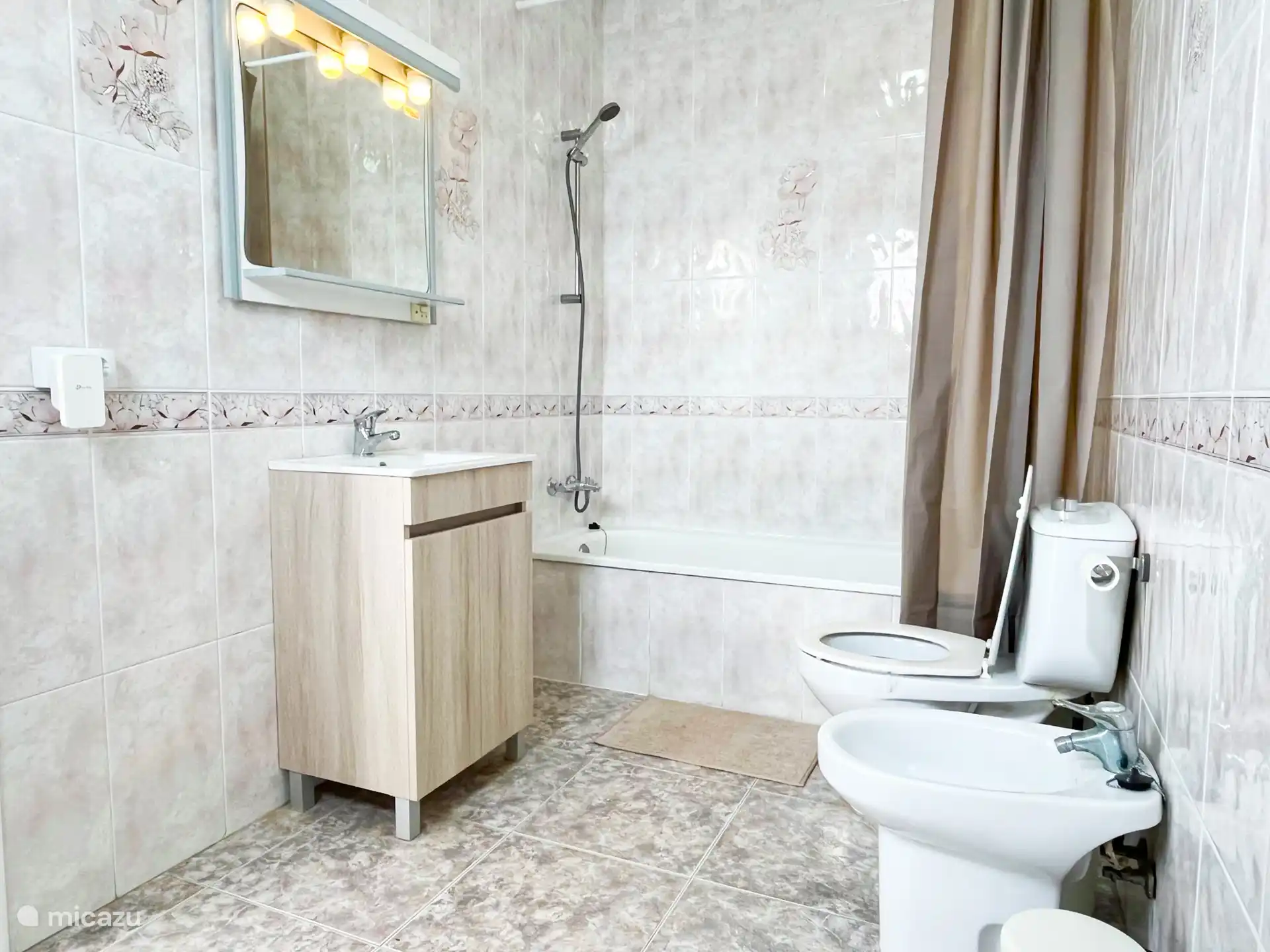 Das Badezimmer: Badewanne, Dusche, Waschbecken, WC, Bidet, Spiegel.