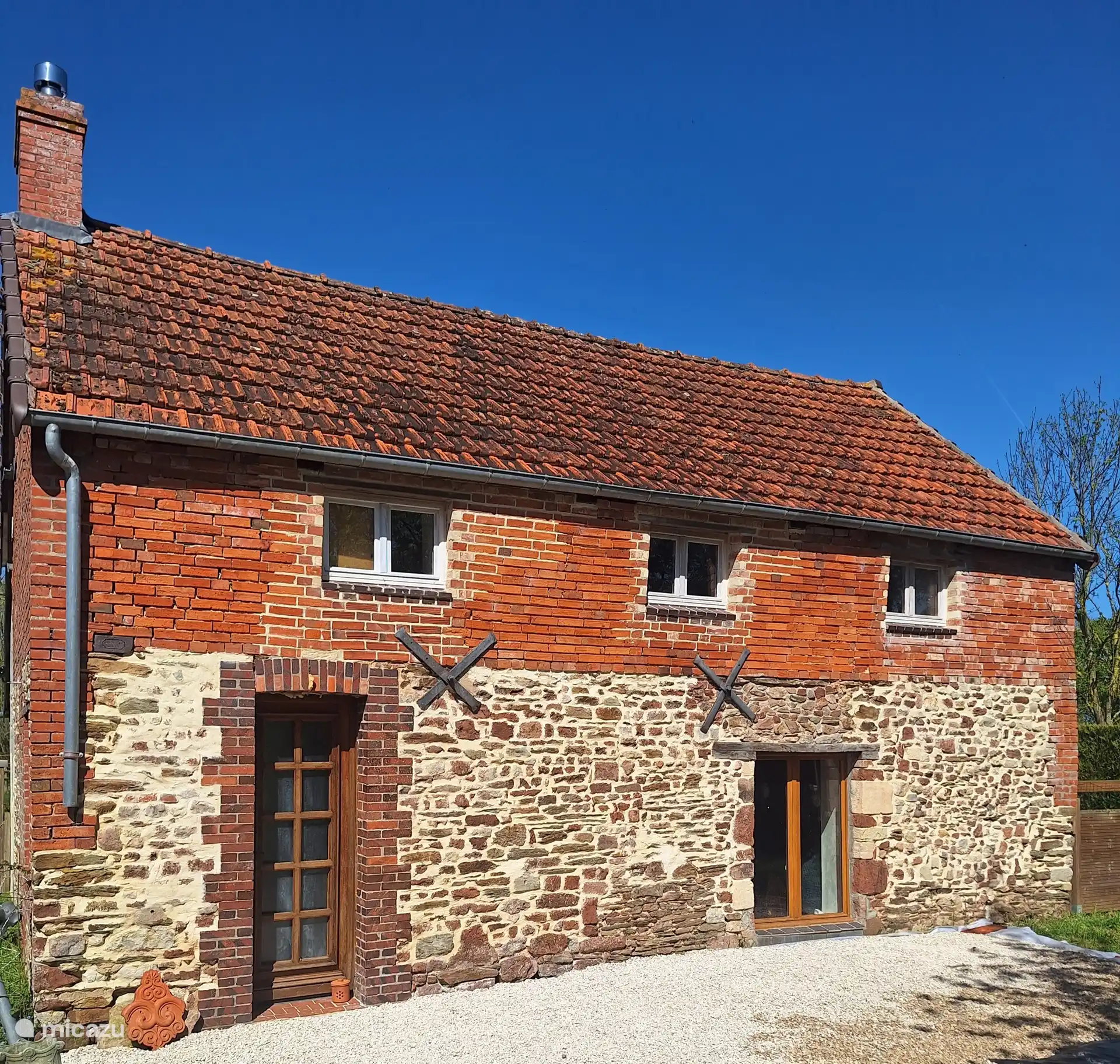 Voorkant van het huisje La perle waar je makkelijk met 2 auto's kan parkeren maar ook in de ochtend zo kan genieten van je ontbijt.