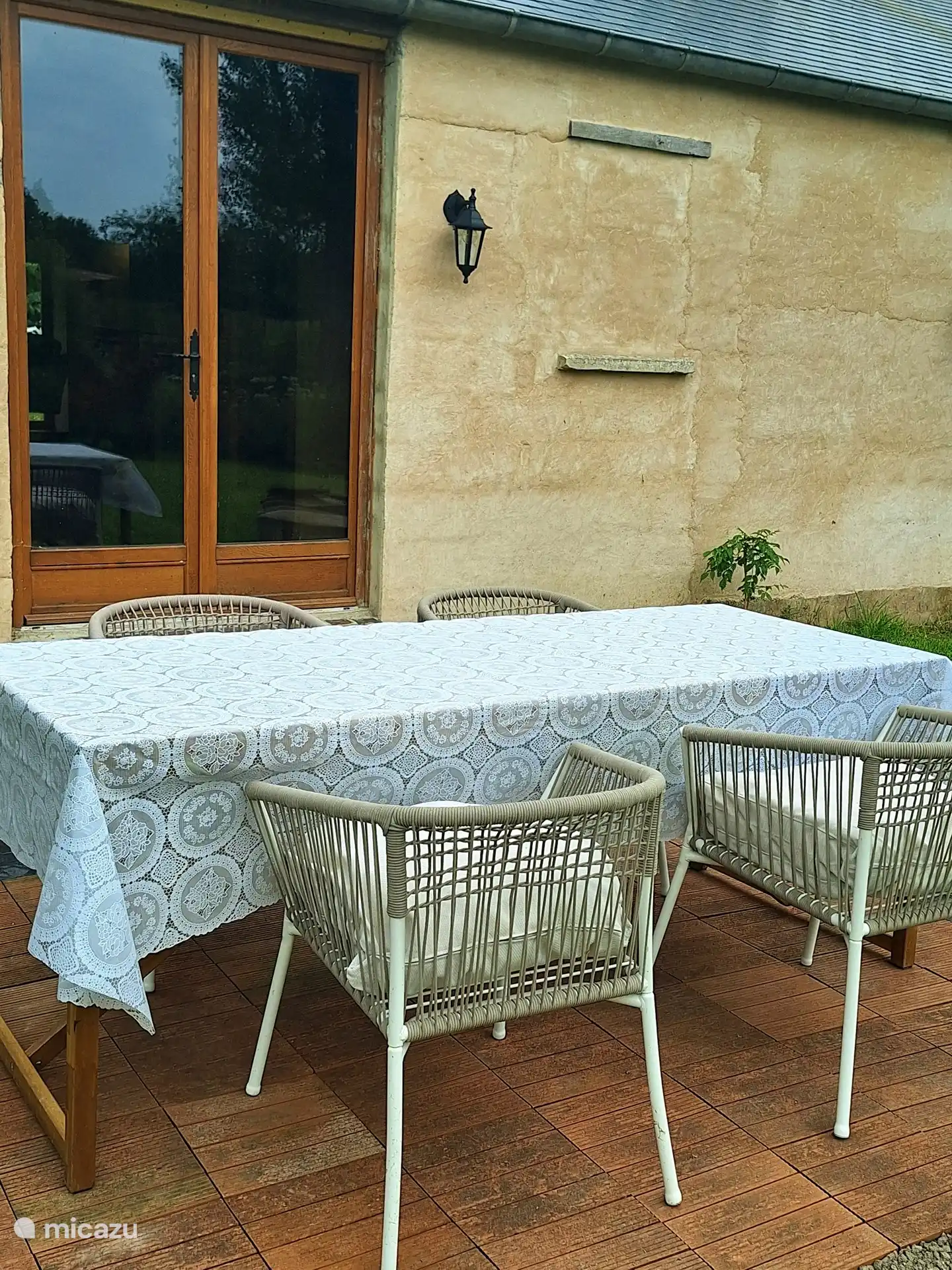 In the morning you can sit at the back and the table with chairs is placed in such a way that you get the sun there first. The back of the house overlooks the garden and pond. There are 2 pairs of French doors. Here you come out of the living room. On the other side there are French doors from the kitchen