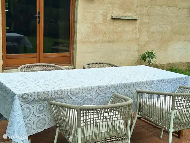 La perle huren in Frankrijk, Calvados, Lison - gîte / cottage In de ochtend kan je heerlijk achter zitten en is de tafel met stoelen zo geplaatst dat je daar het eerst zon krijgt. De achterkant van het huis kijkt op de tuin en vijver uit. Er zijn 2 paar tuindeuren. Hier kom je uit de woonkamer naar buiten. Aan de andere kant zijn er tuindeuren vanuit de keuken