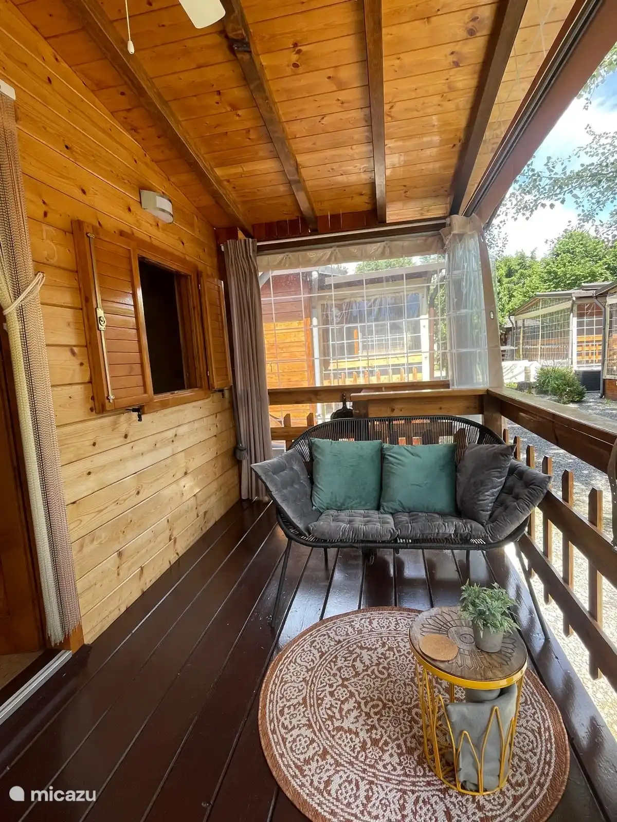 The veranda has a lounge sofa and dining table