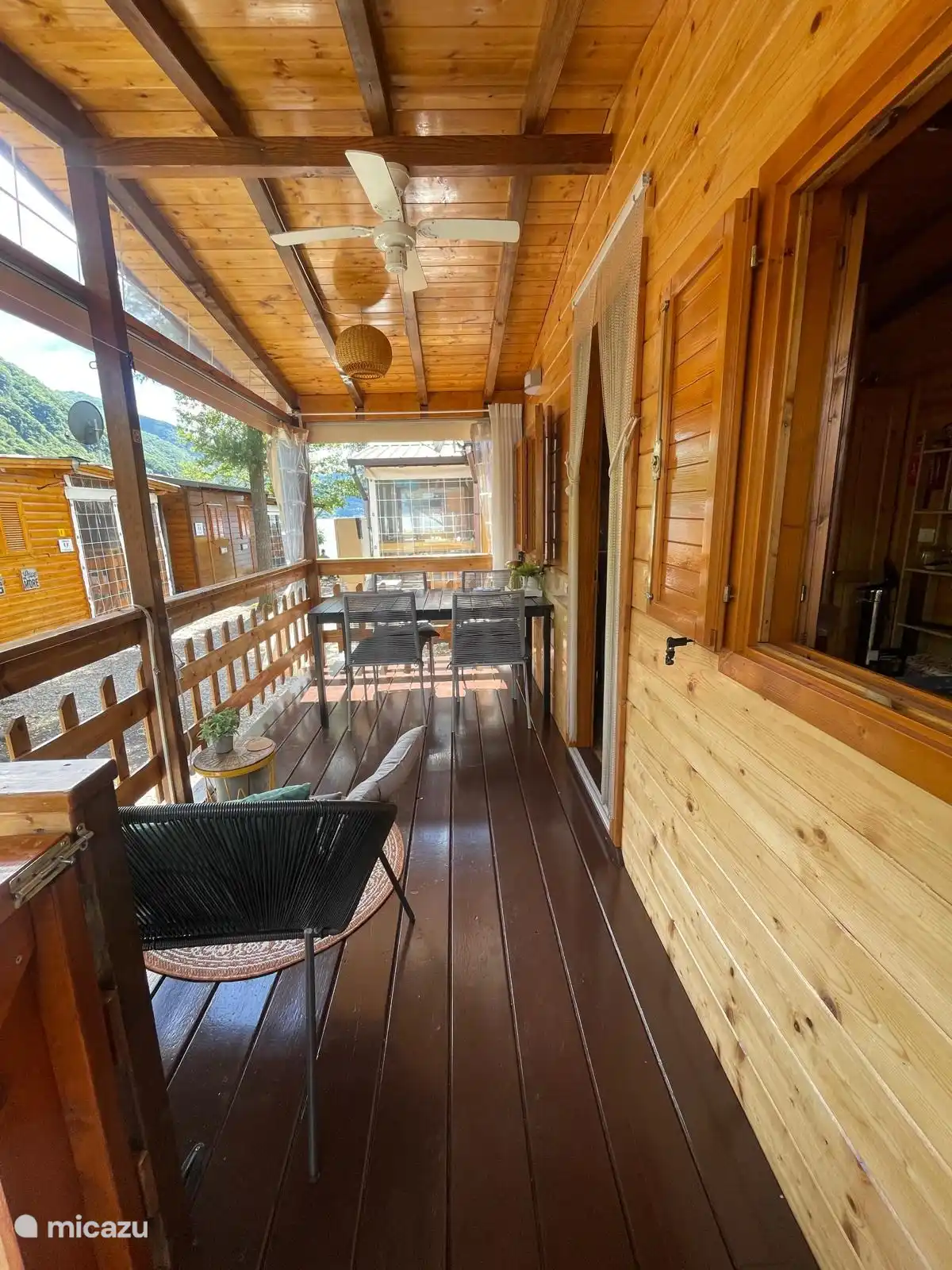 The veranda has a lounge sofa and dining table