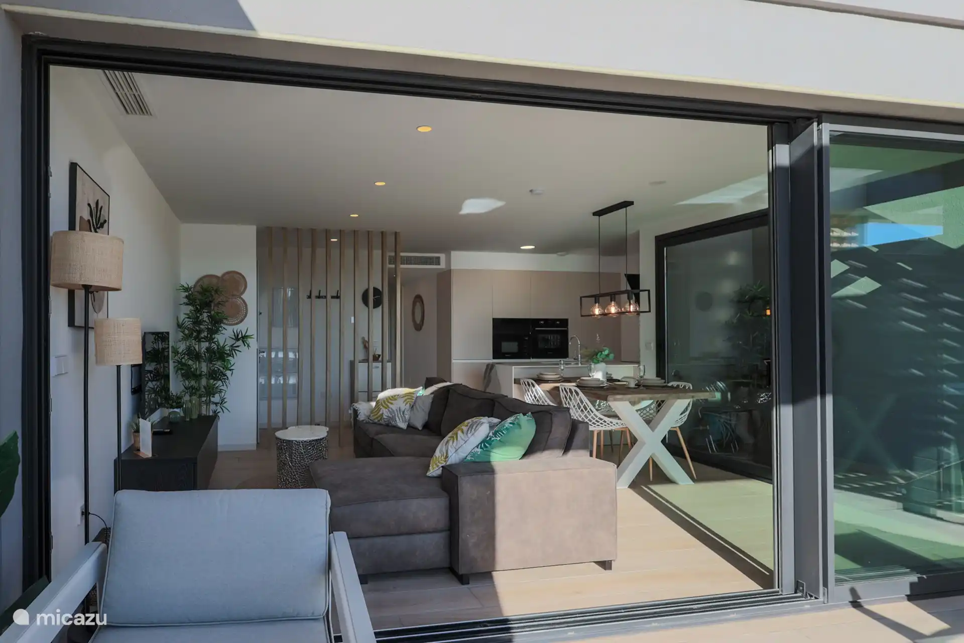 Das große Wohnzimmer vom Balkon aus. Die riesige Schiebetür besteht aus drei Teilen. Fantastisch im Sommer!