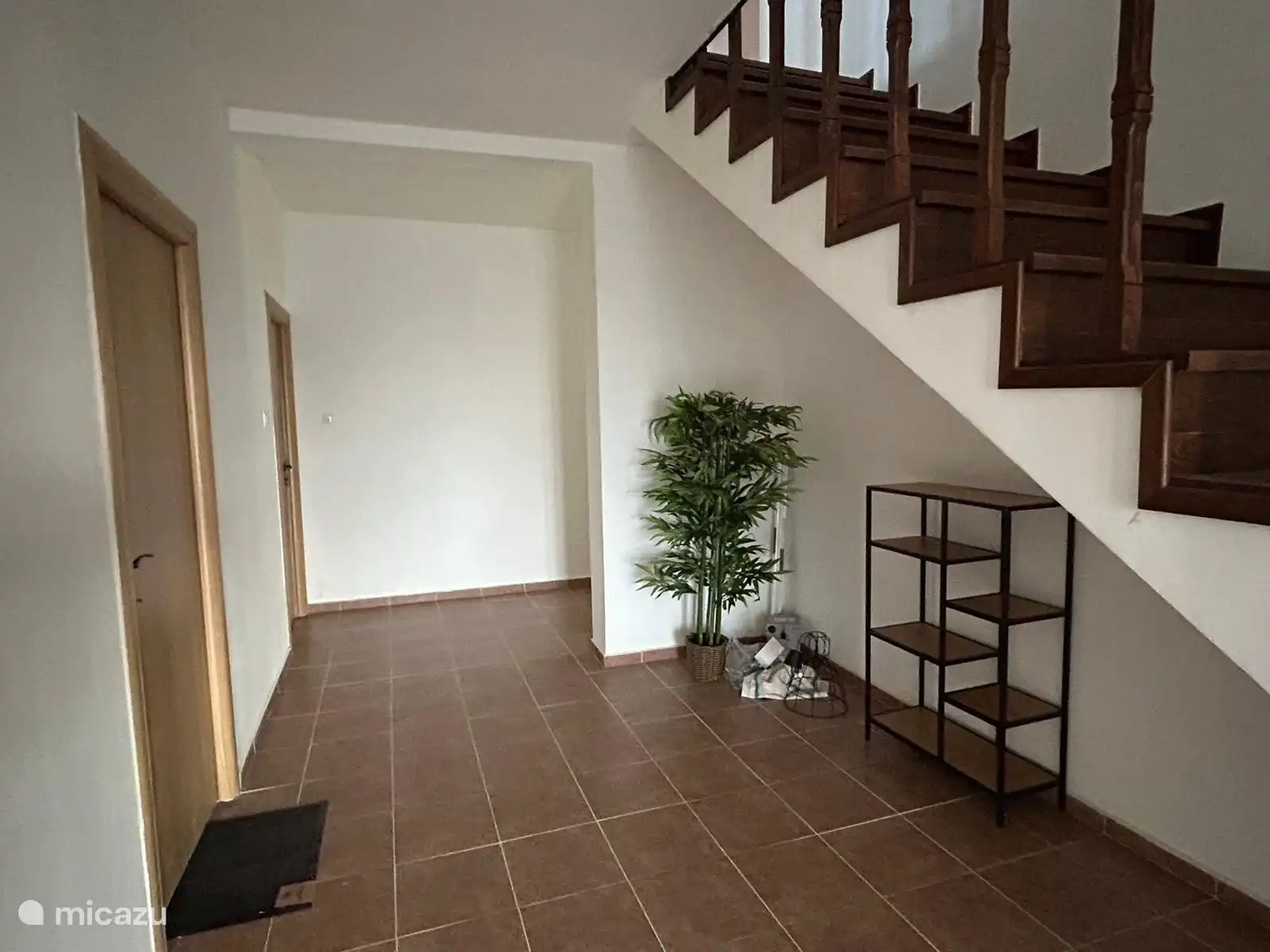 Hall spacieux avec accès au garage (intérieur), chambre et escalier menant au premier étage