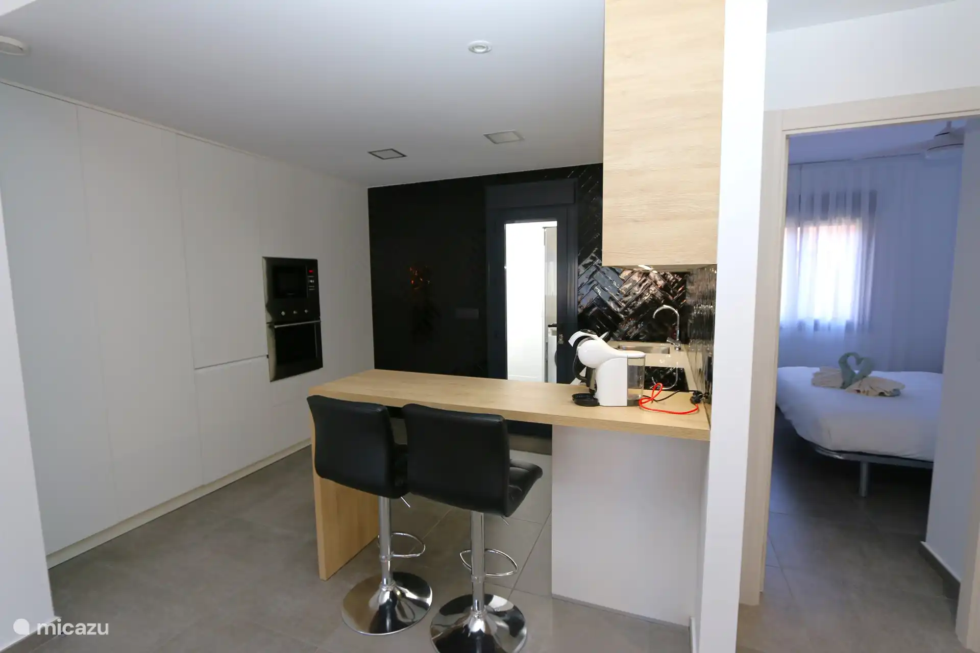 The breakfast bar and the kitchen of the apartment.