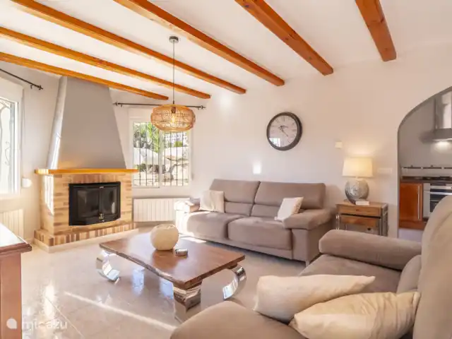 Villa Jacaranda huren in Spanje, Costa Blanca, Alcalali - villa De woonkamer is sfeervol ingericht, eethoek met grote eettafel, ruime zithoek met open haard, muziekinstallatie, airconditioning, plafondventilator en horren voor de ramen. Er is een smart TV aanwezig, u kunt inloggen op je eigen streamingdienst op de tv.