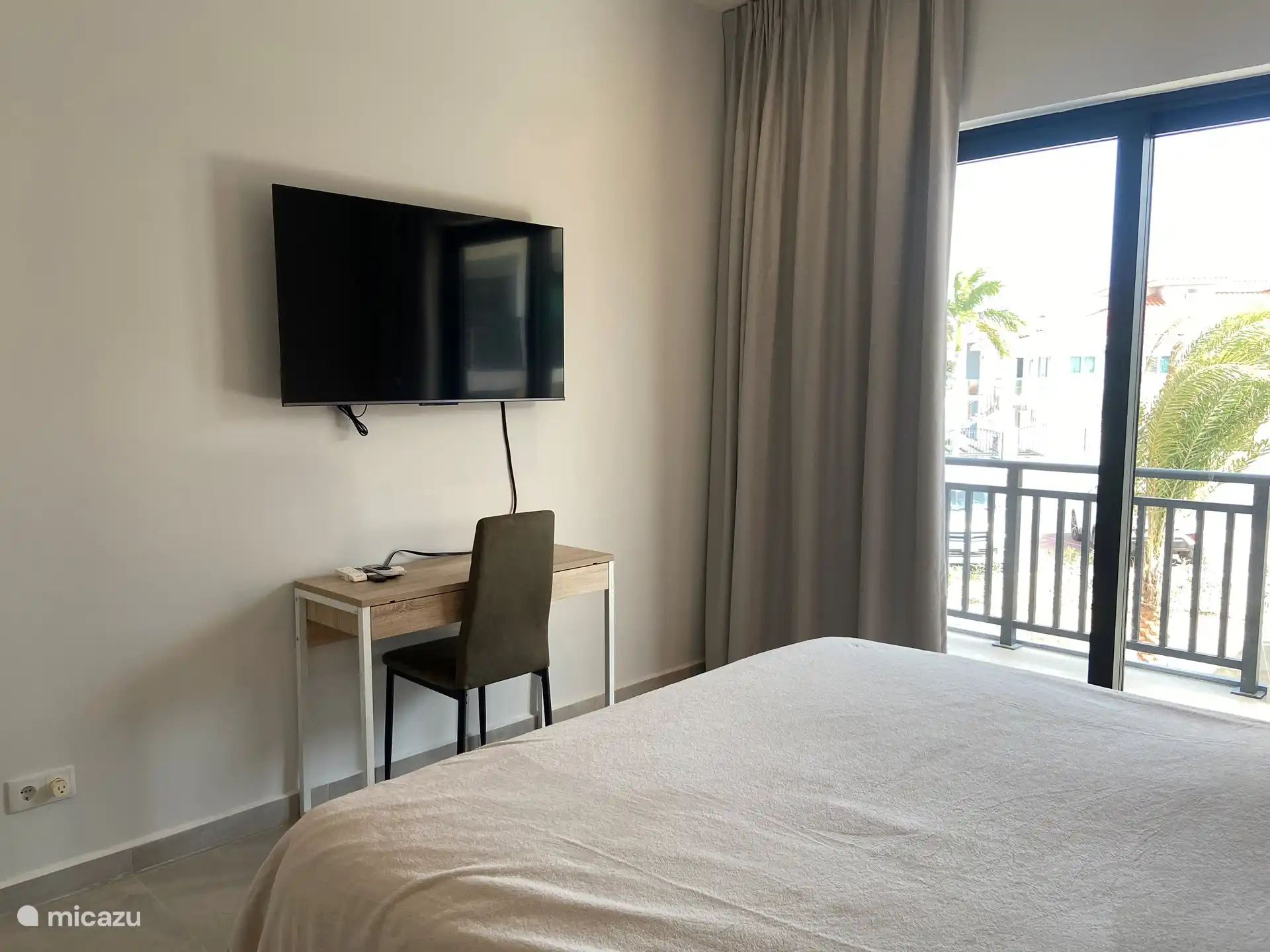 Schlafzimmer 2 mit TV, Arbeitsbereich und Schiebetür zur Terrasse