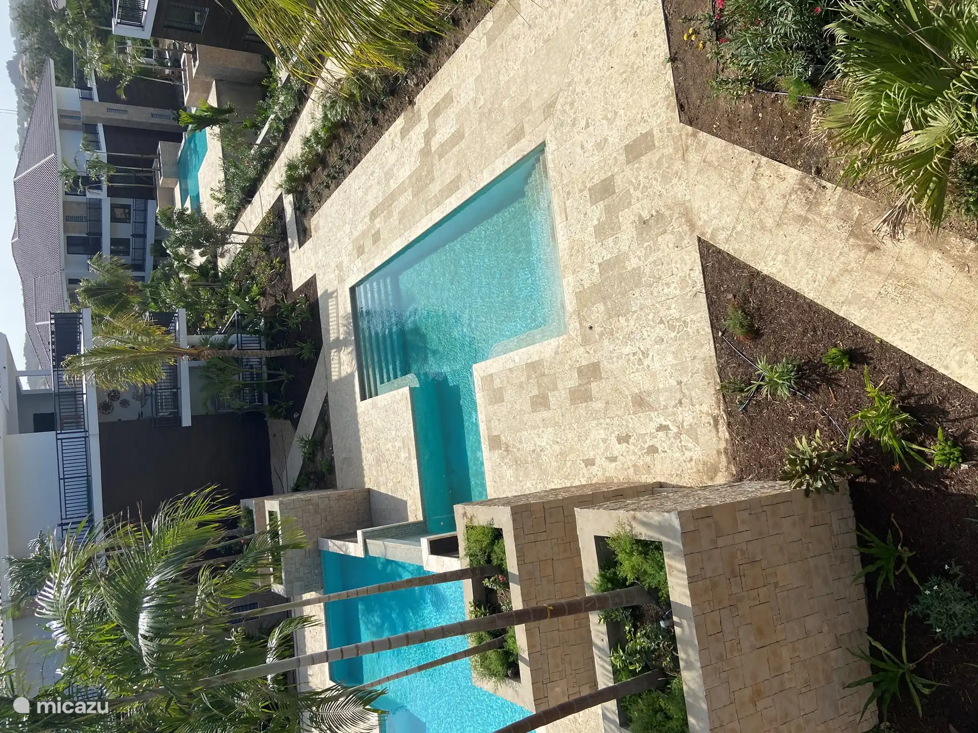 Einer der beiden Swimmingpools zwischen den Häusern von der Terrasse aus gesehen