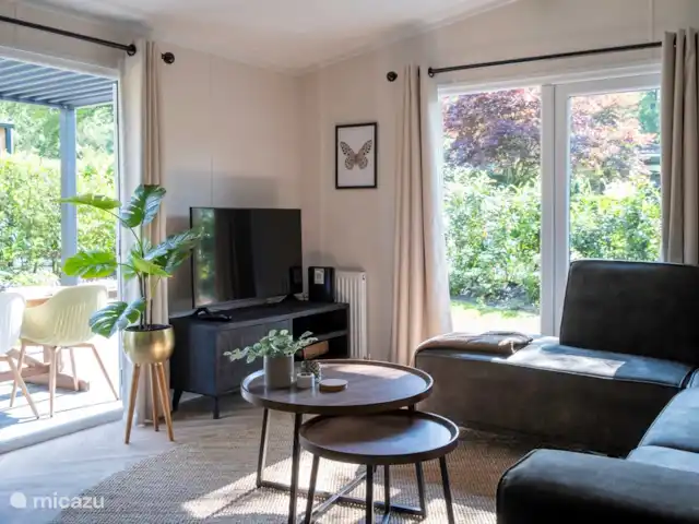 Nuestra casa de campo en el Veluwe: Pinecone en Países Bajos, Güeldres, Beekbergen - chalet Sala de estar con 2 puertas francesas. Smart TV con conexión WiFi para que puedas hacer streaming.