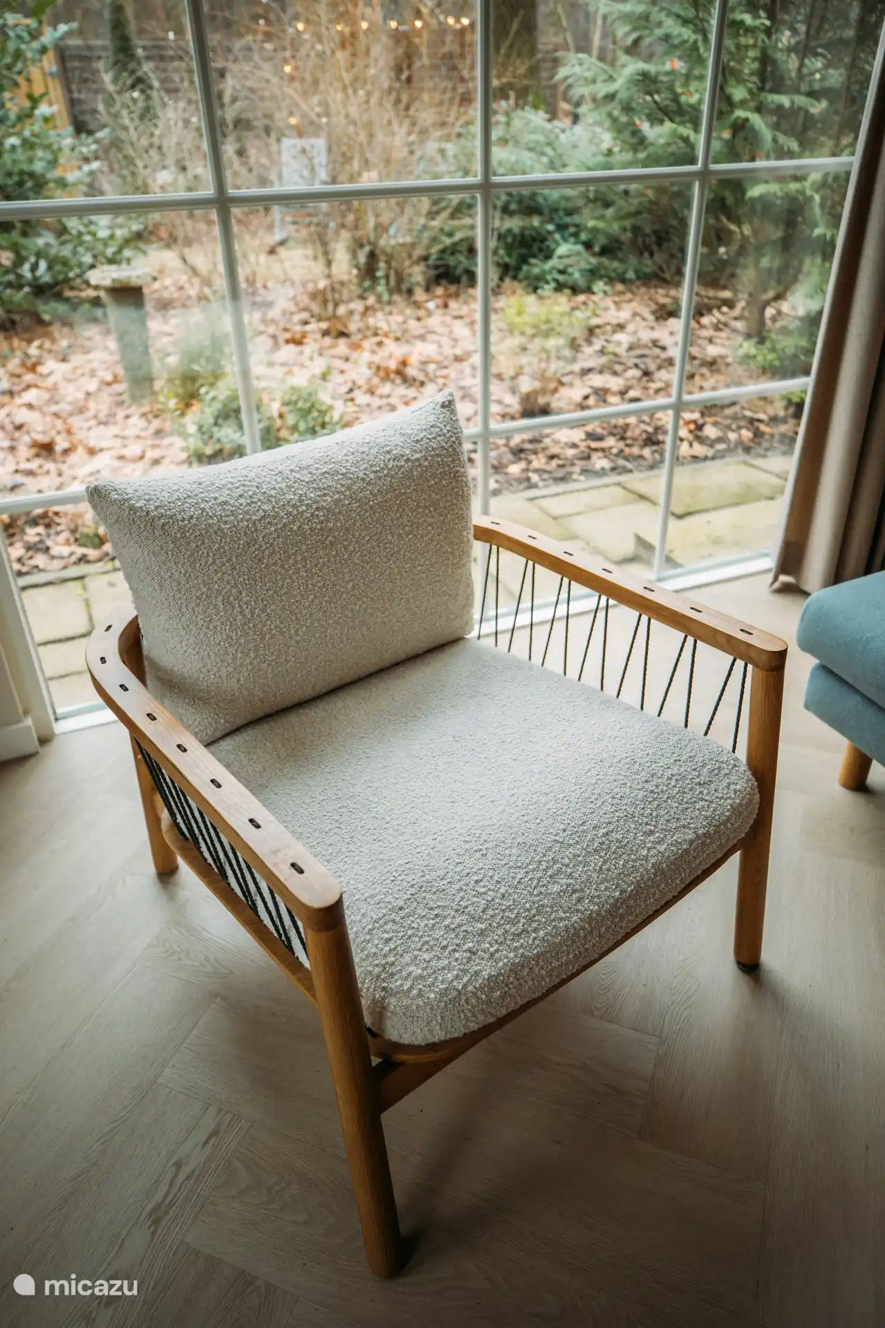 Sillón cómodo junto a la ventana con vistas al bosque. Ideal para relajarse.