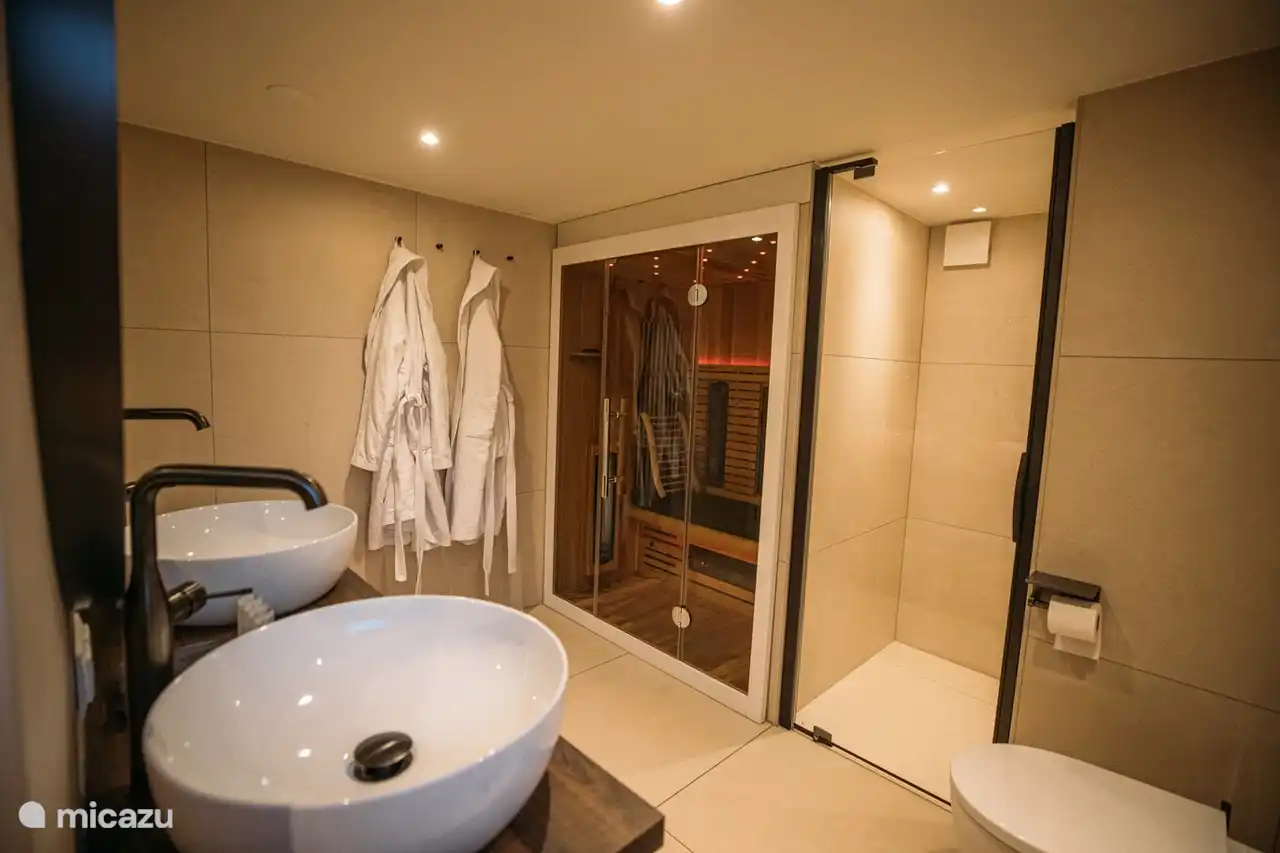 Baño de bienestar con sauna, ducha y bañera.