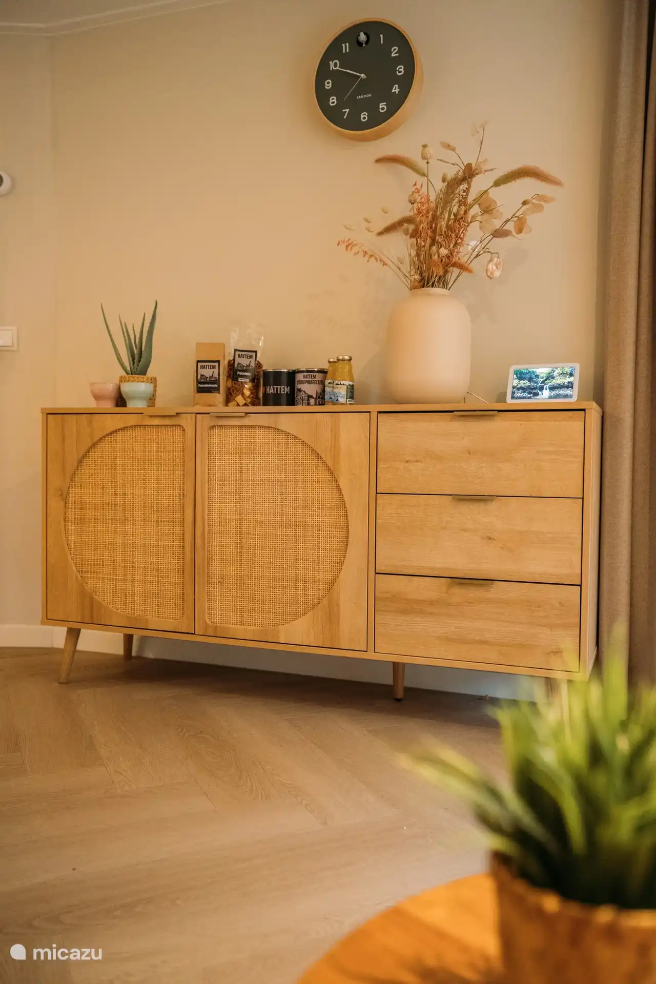 Aparador elegante con decoración en tonos naturales que combinan con el interior.