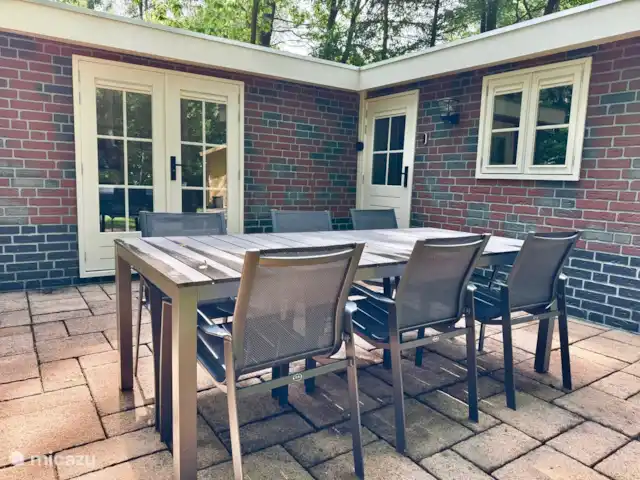 Maison de vacances Maridu Family Wellness | Pays-Bas, Gueldre, Hattemerbroek - chalet La photo montre un coin salon confortable avec une table à manger sur la terrasse. Un endroit parfait pour prendre des repas ensemble en plein air, entourés de verdure et de tranquillité. Idéal pour un petit-déjeuner tranquille, un barbecue ou une soirée agréable sous les étoiles.