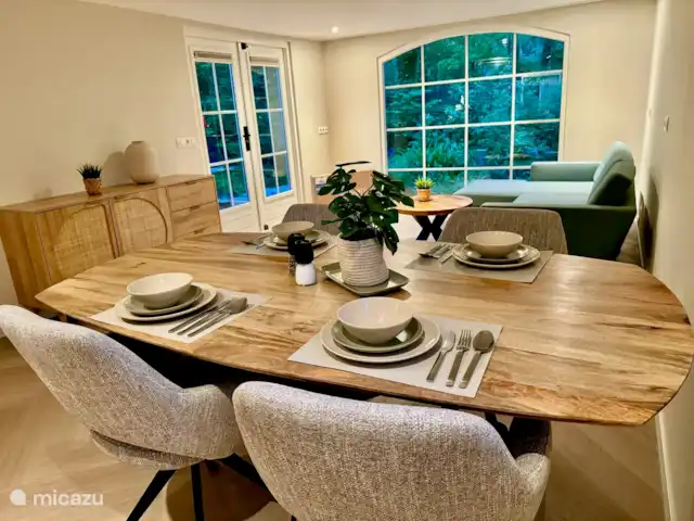 Maison de vacances Maridu Family Wellness | Pays-Bas, Gueldre, Hattemerbroek - chalet La table à manger offre une belle vue sur le salon confortable, avec une armoire en bois élégante sur la gauche qui ajoute de la chaleur et du caractère. Les grandes fenêtres offrent beaucoup de lumière naturelle et une vue sur le jardin, permettant à la nature d’être ressentie de chaque partie du salon.