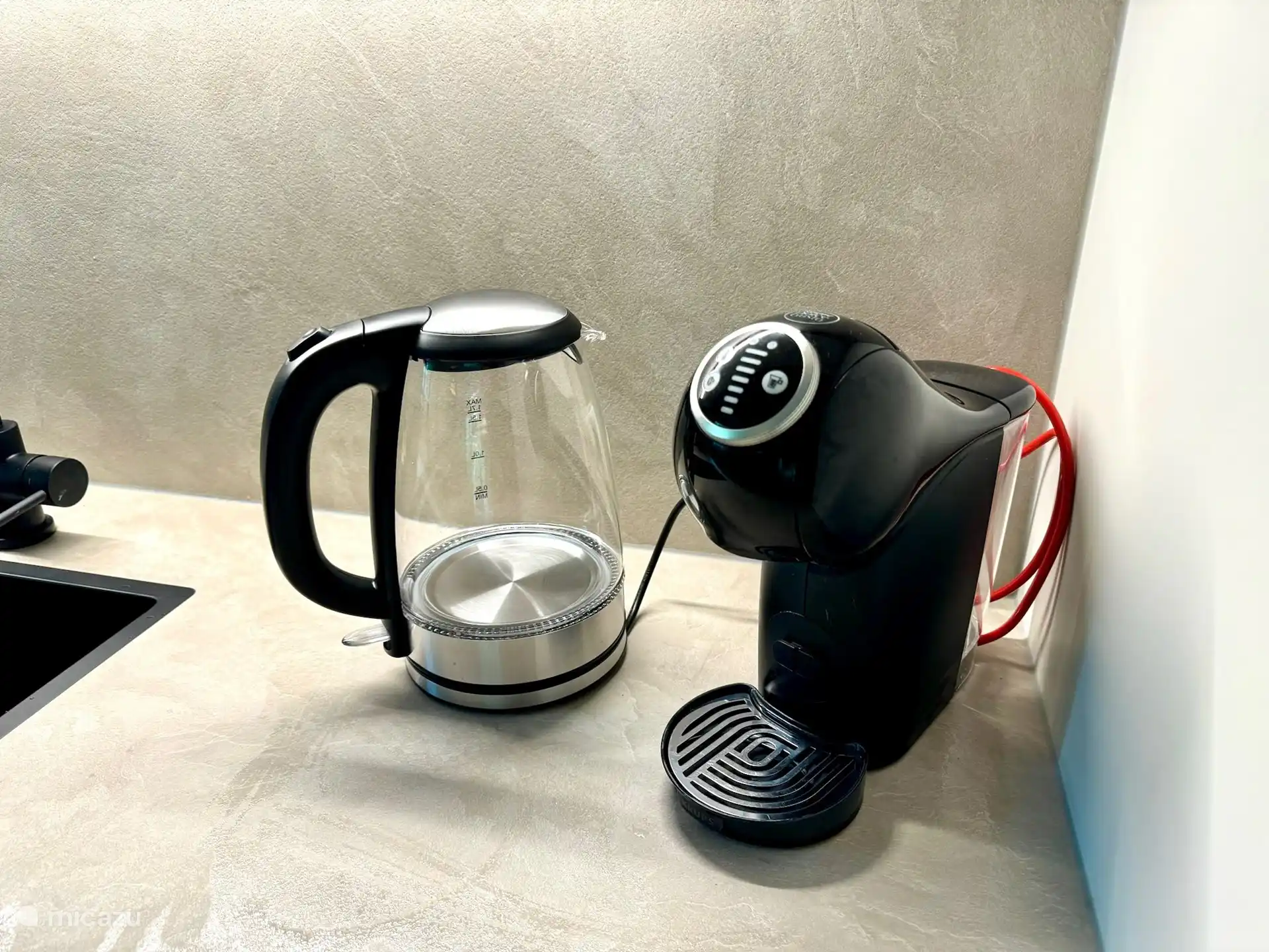 Die Küche ist mit einem praktischen Wasserkocher und einer Dolce Gusto-Kaffeemaschine ausgestattet, mit der Sie im Handumdrehen eine Tasse Tee oder Ihren Lieblingskaffee genießen können. Perfekt für einen entspannten Start in den Tag oder einen Moment der Ruhe während Ihres Aufenthalts.