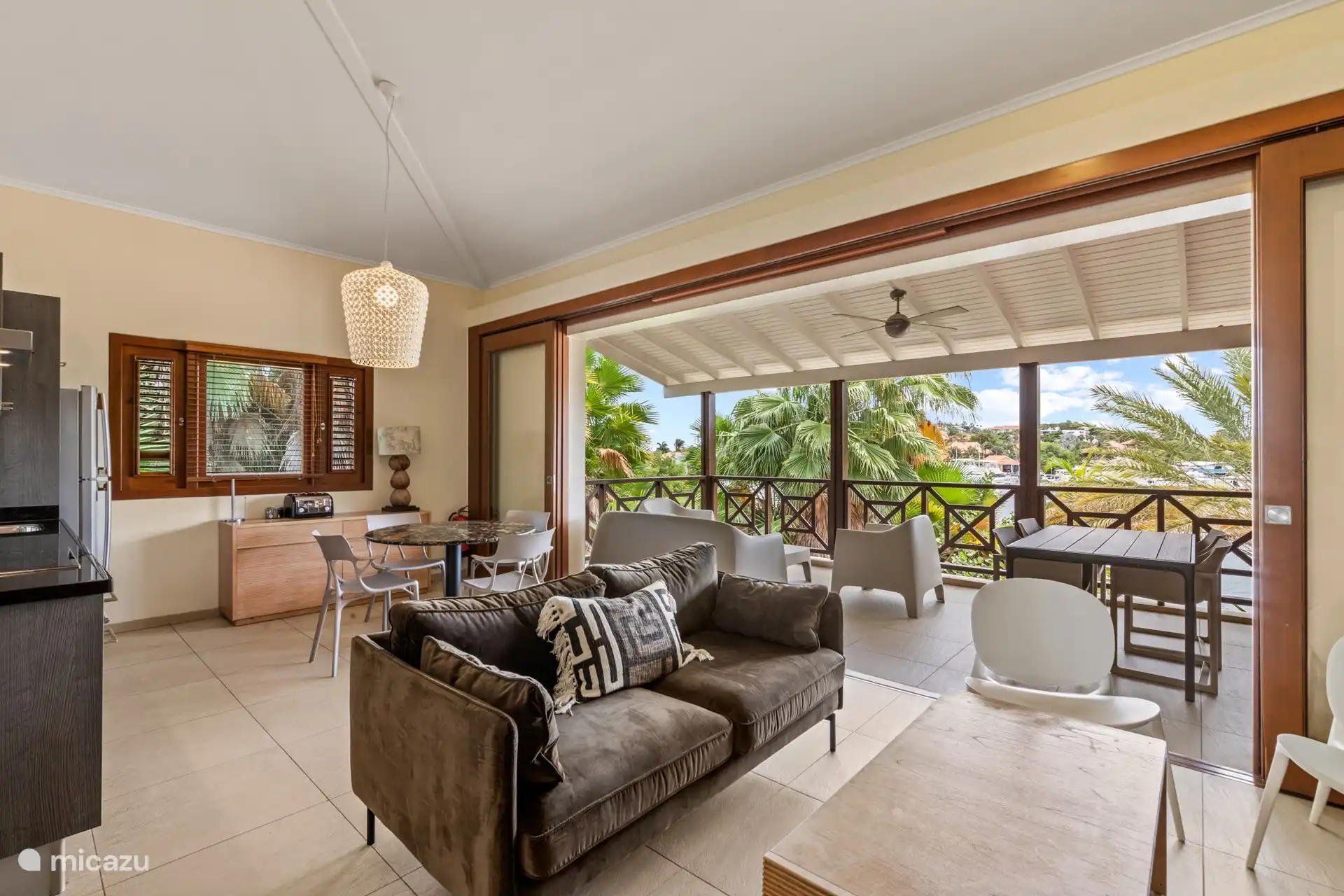 Wohnzimmer, das durch die Glastüren nahtlos in den Balkon übergeht. 