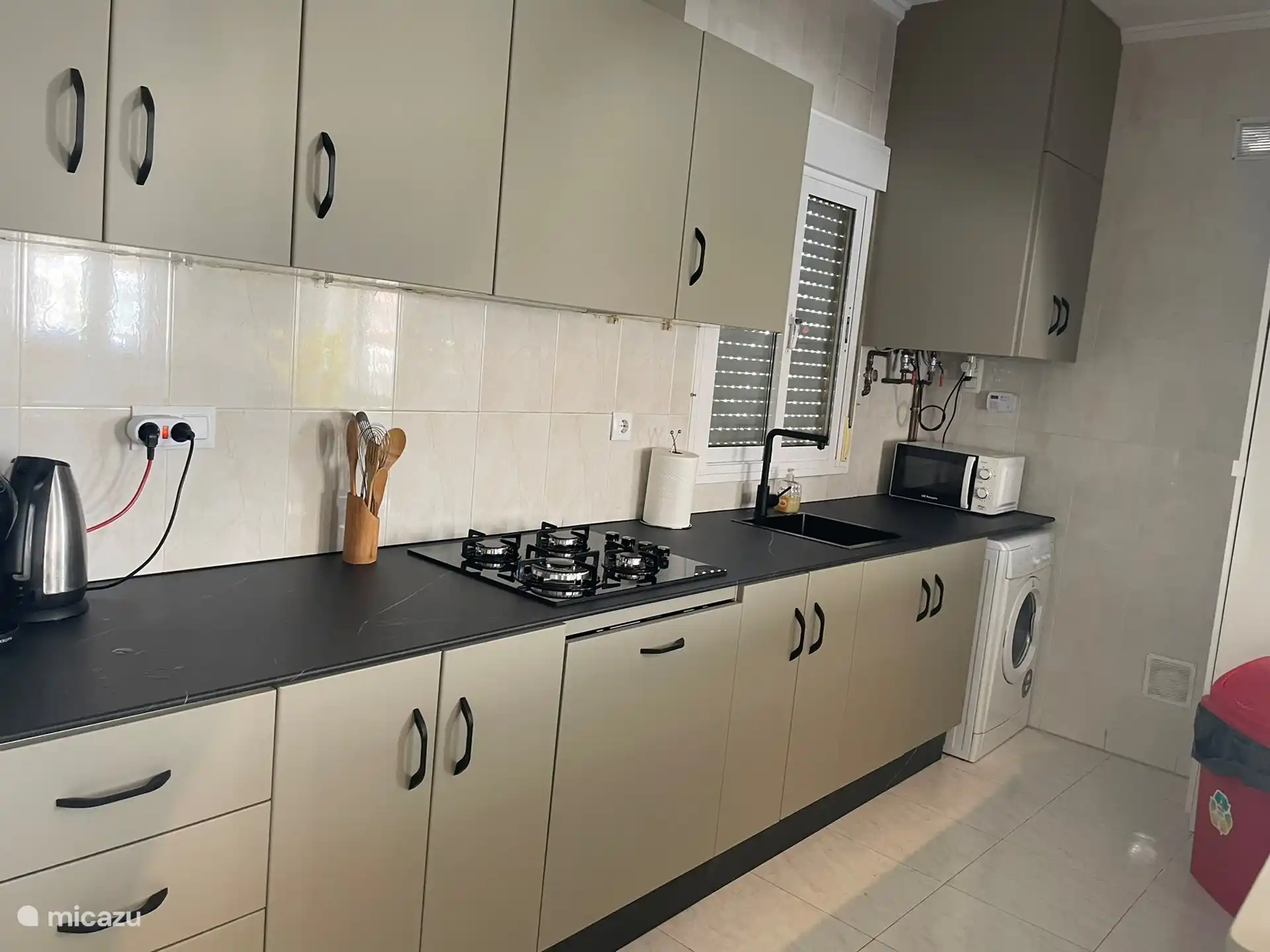 Küche mit großem Gefrierschrank und großem Kühlschrank, Herd, Geschirrspüler und Mikrowelle. 