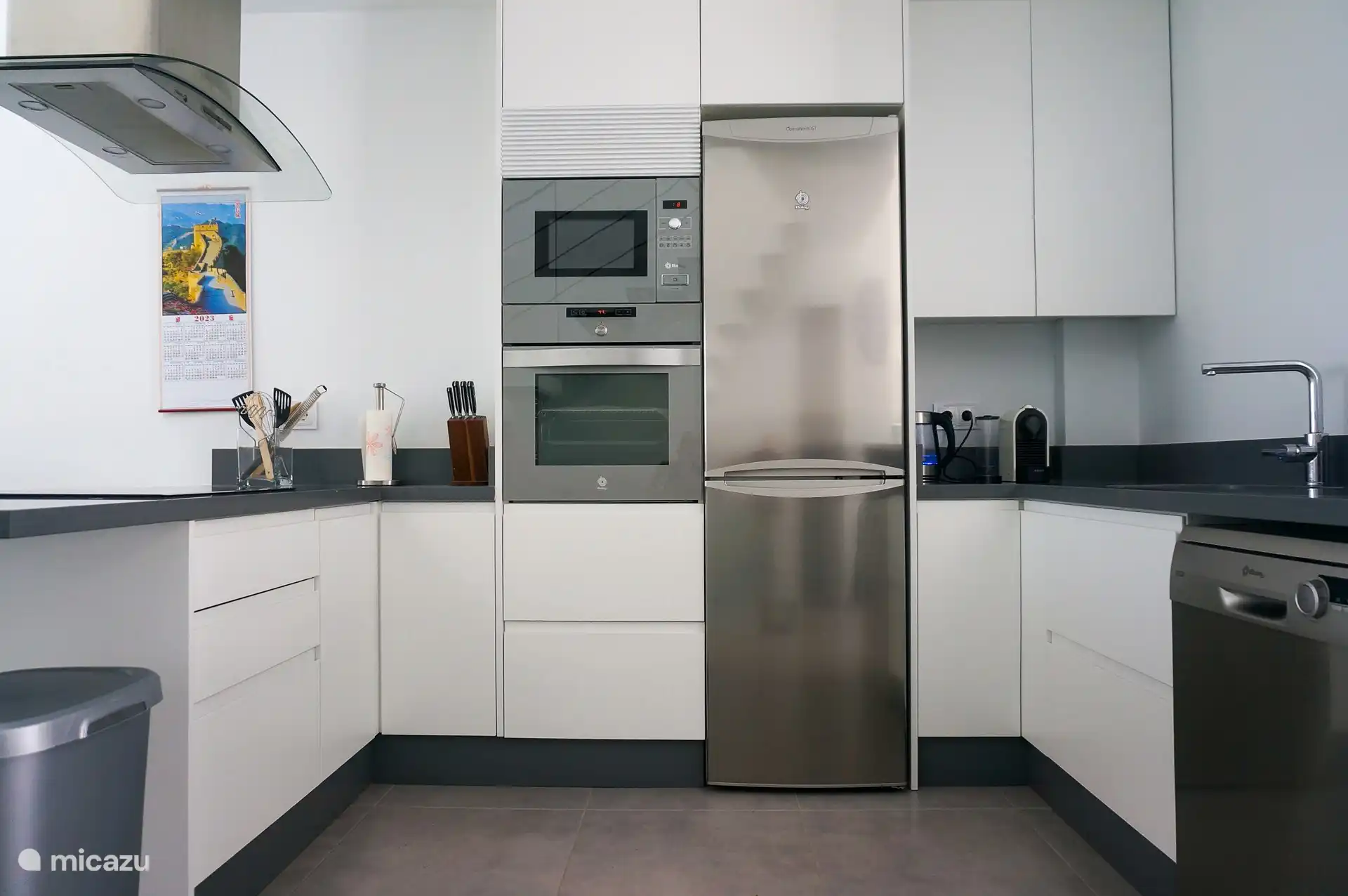 Cuisine ouverte avec micro-ondes, four, lave-vaisselle, cafetière Nespresso, grille-pain et autres appareils de cuisine.