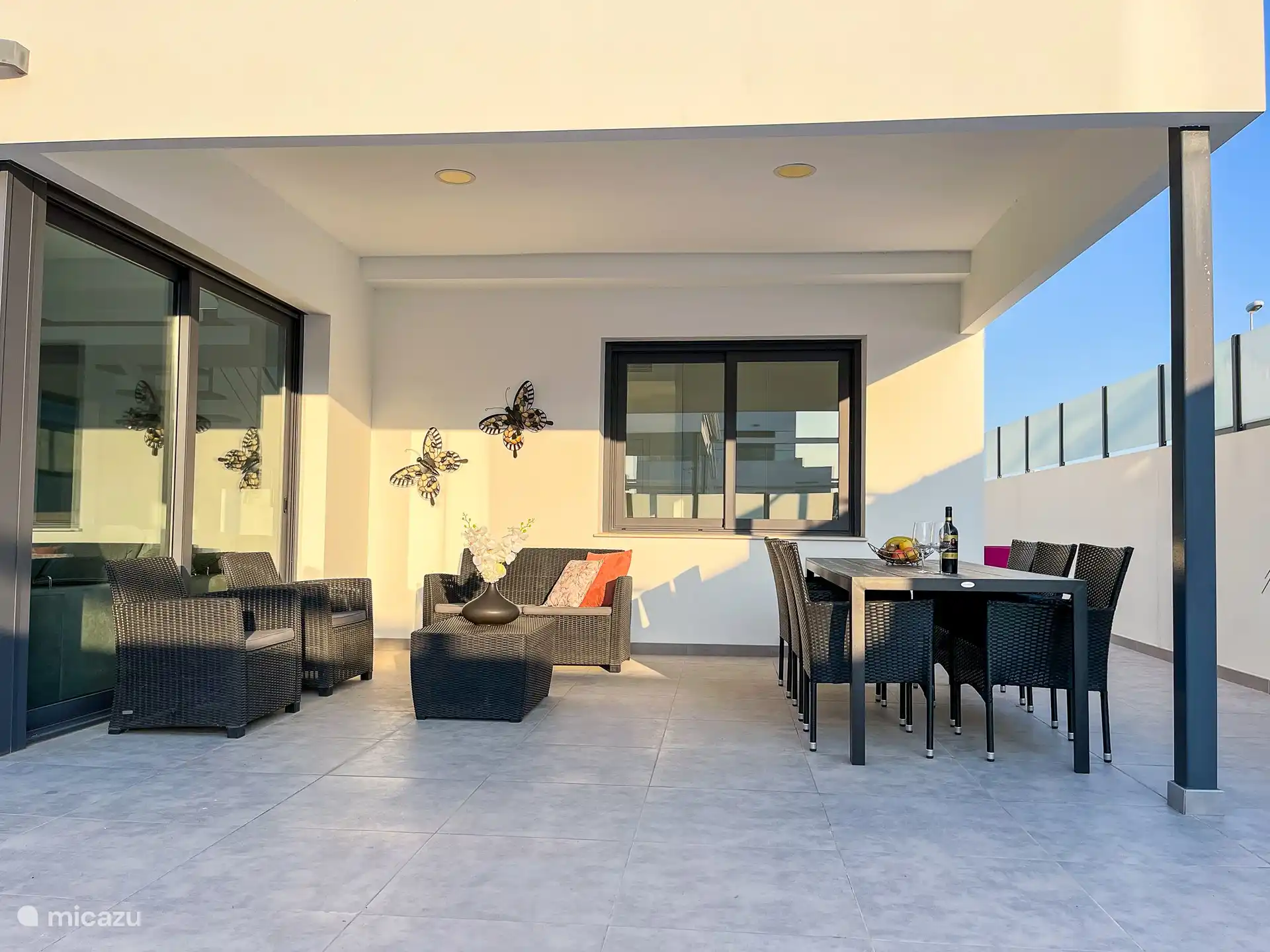 Une véranda avec un coin salon confortable, ce qui en fait un bon endroit pour séjourner par temps chaud. 