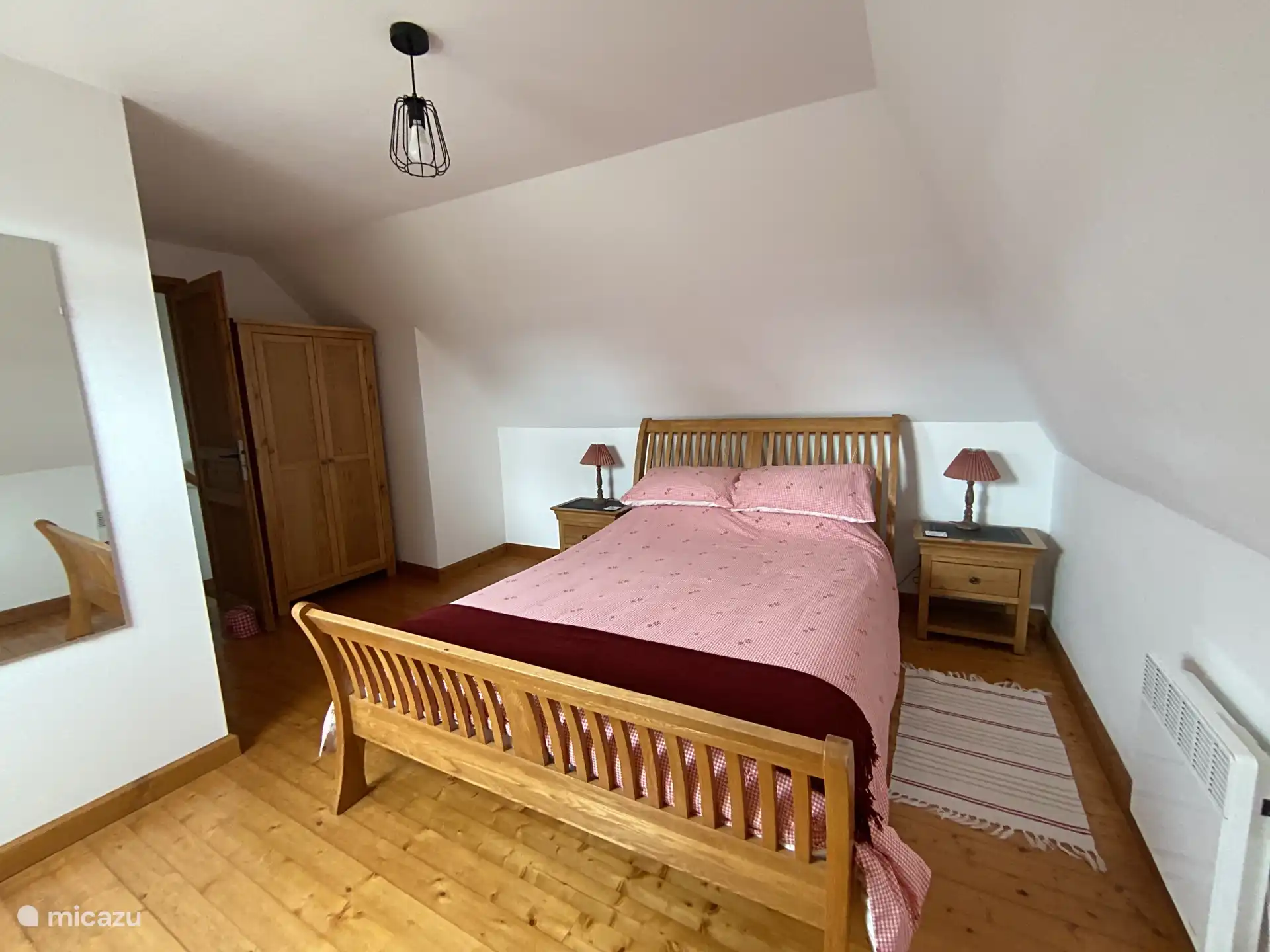 Chambre principale avec lit king size en chêne et tables de chevet assorties.