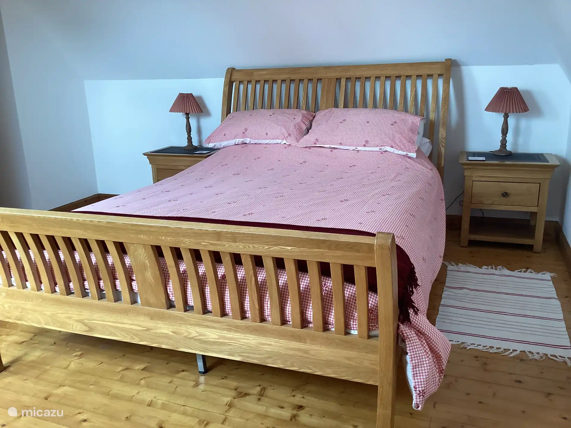 Chambre principale avec lit king size en chêne, armoires de chevet assorties, armoire. 