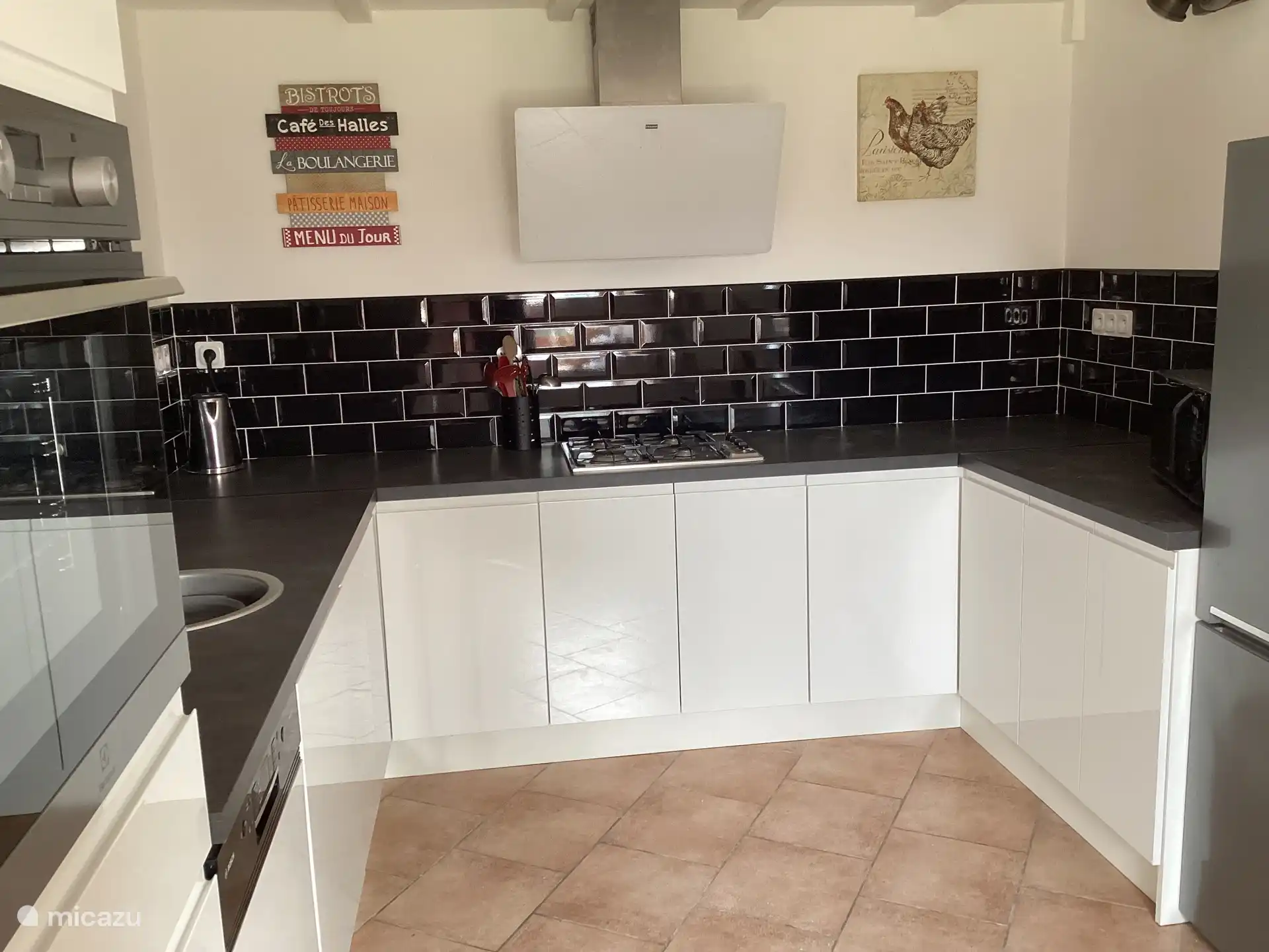 Keuken met gasfornuis, elektrische oven, vaatwasser, wasmachine, magnetron en koelkast en vriezer