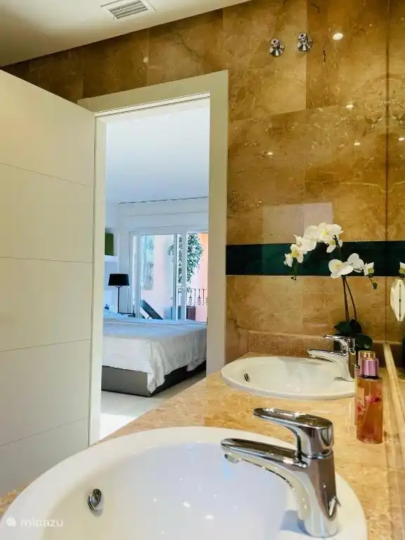 La chambre principale avec la salle de bain spacieuse