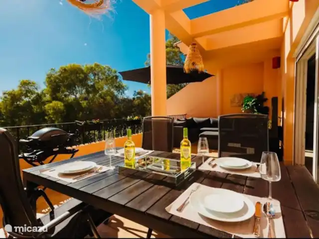 Location de Vacances Espagne, Costa del Sol, Marbella, penthouse - VistaReal Marbella Le plus grand balcon du rez-de-chaussée avec salon pour 7 personnes, table à manger pour 6 personnes, cascade illuminée, barbecue électrique Weber et parasol