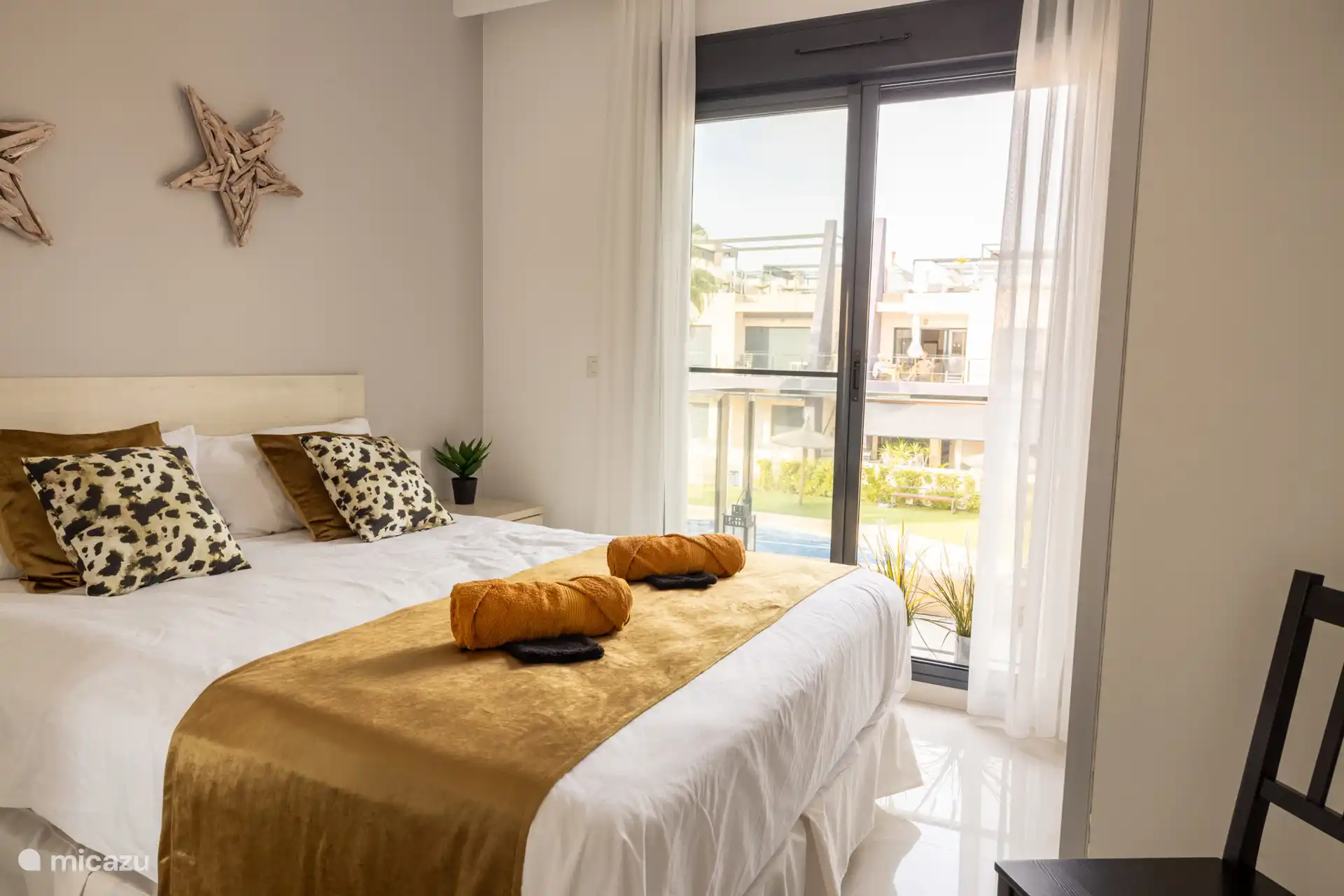 El dormitorio principal con puertas correderas. En el balcón y la piscina con vistas