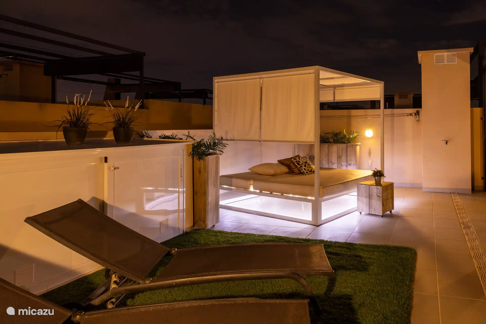 Atractivo sillón en la terraza de la azotea y tumbonas