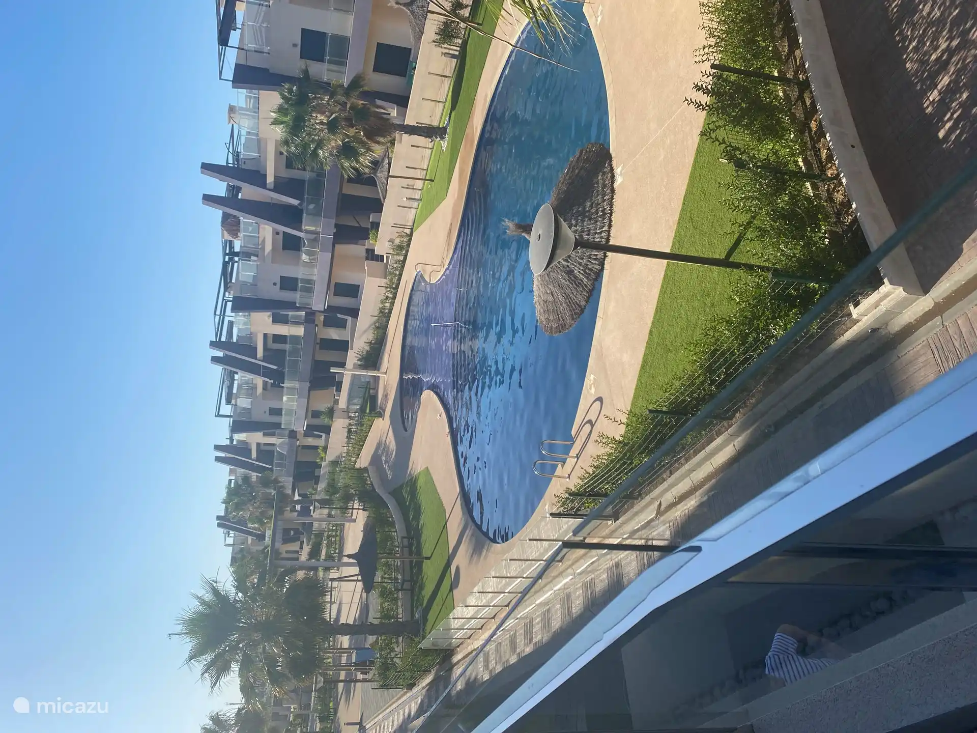 Se mira desde la azotea y la terraza de abajo a la gran piscina