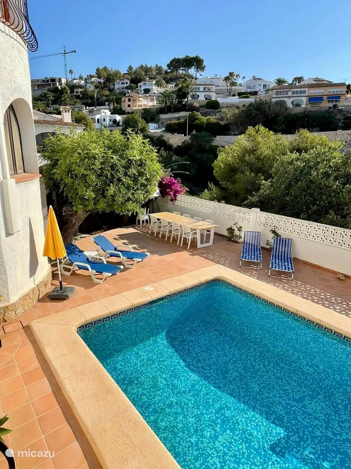 Piscine avec grande table de terrasse avec 8 chaises, transats et parasol