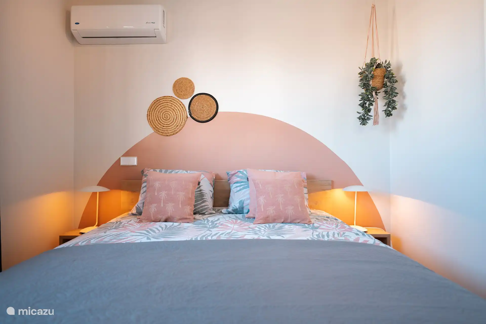 Air-conditioned bedroom with a double bed and large wardrobe. 