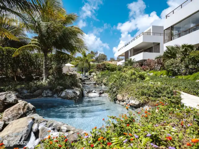Location de Vacances Curaçao, Curaçao-Centre, Willemstad, appartement - Appartement Mariposa - LUX Les belles cascades, où vous pouvez également vous asseoir dans cette section. Parmi les plantes tropicales.
