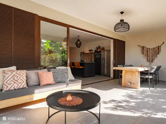 Location de Vacances Curaçao, Curaçao-Centre, Willemstad, appartement - Appartement Mariposa - LUX La terrasse extérieure avec une grande table à manger et un ensemble de salon.