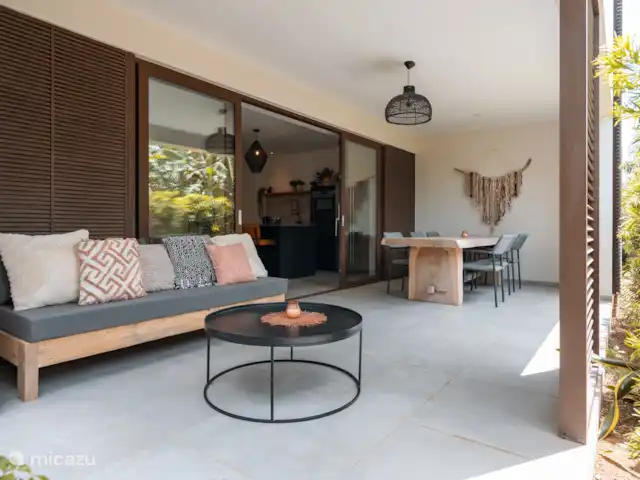 Location de Vacances Curaçao, Curaçao-Centre, Willemstad, appartement - Appartement Mariposa - LUX La terrasse avec de grandes portes-fenêtres donnant sur la cuisine ouverte et le salon.