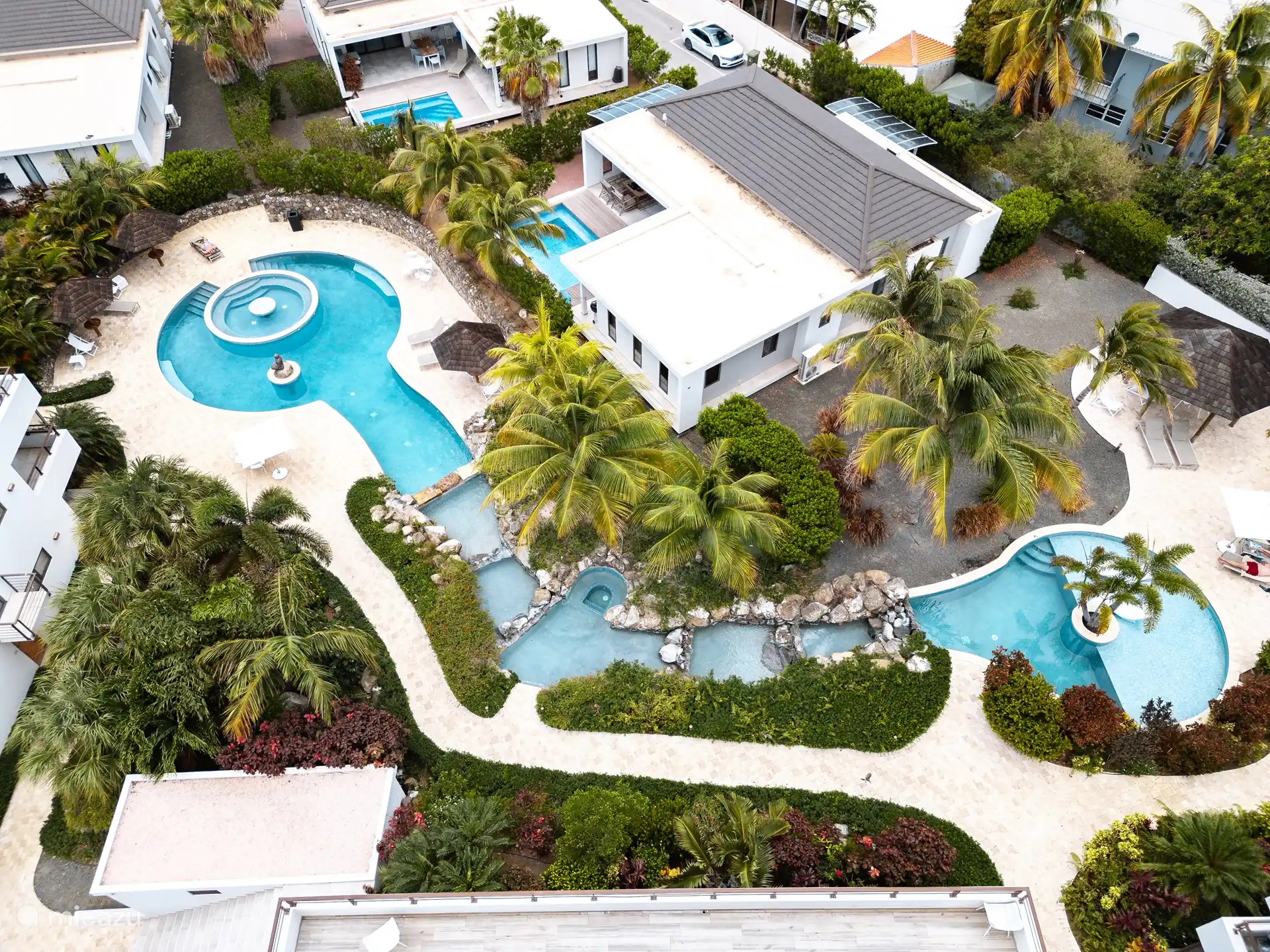 Overview photo of the pool from above. Two large circular pools that are connected to waterfalls. 