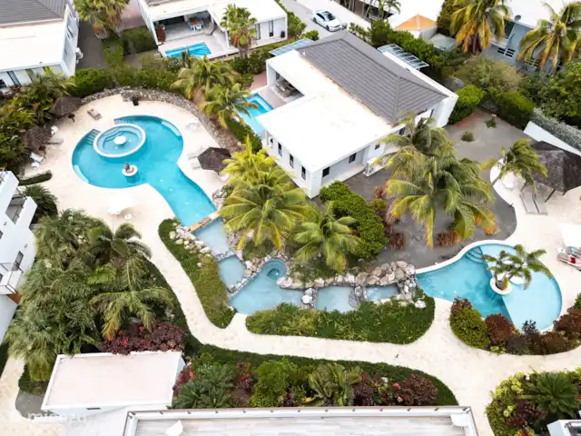 Location de Vacances Curaçao, Curaçao-Centre, Willemstad, appartement - Appartement Mariposa - LUX Photo d’ensemble de la piscine vue d’en haut. Deux grandes piscines circulaires reliées à des cascades.