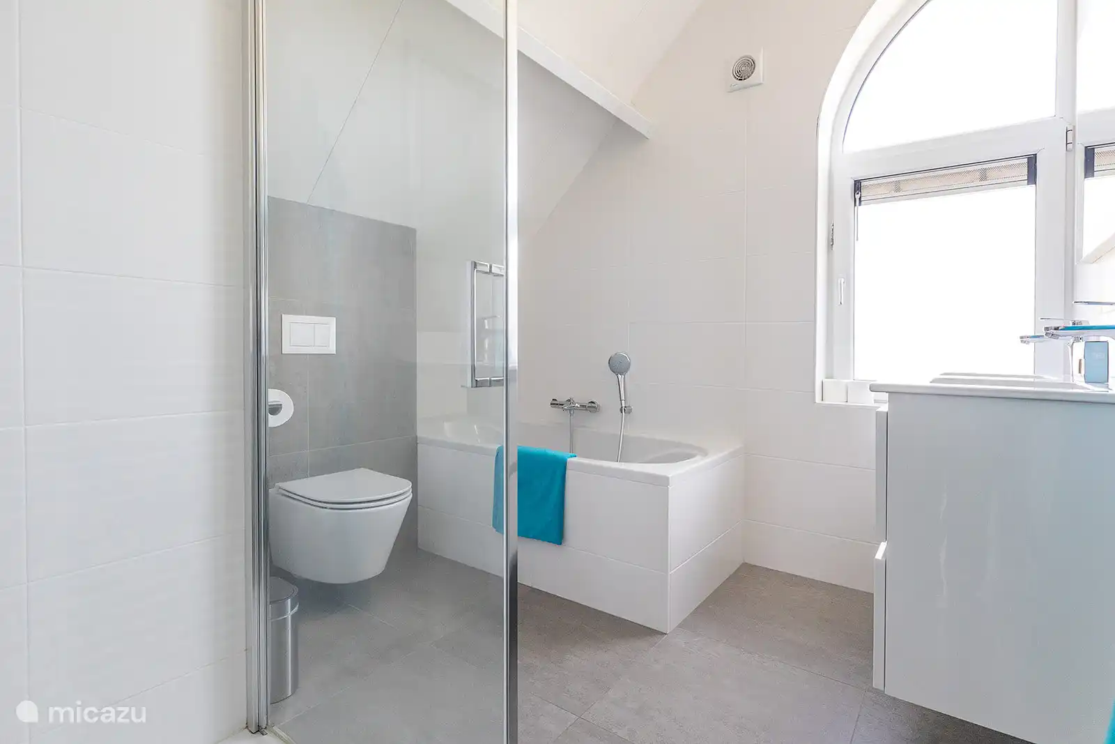 Salle de bain de luxe étendue avec baignoire et douche séparées.