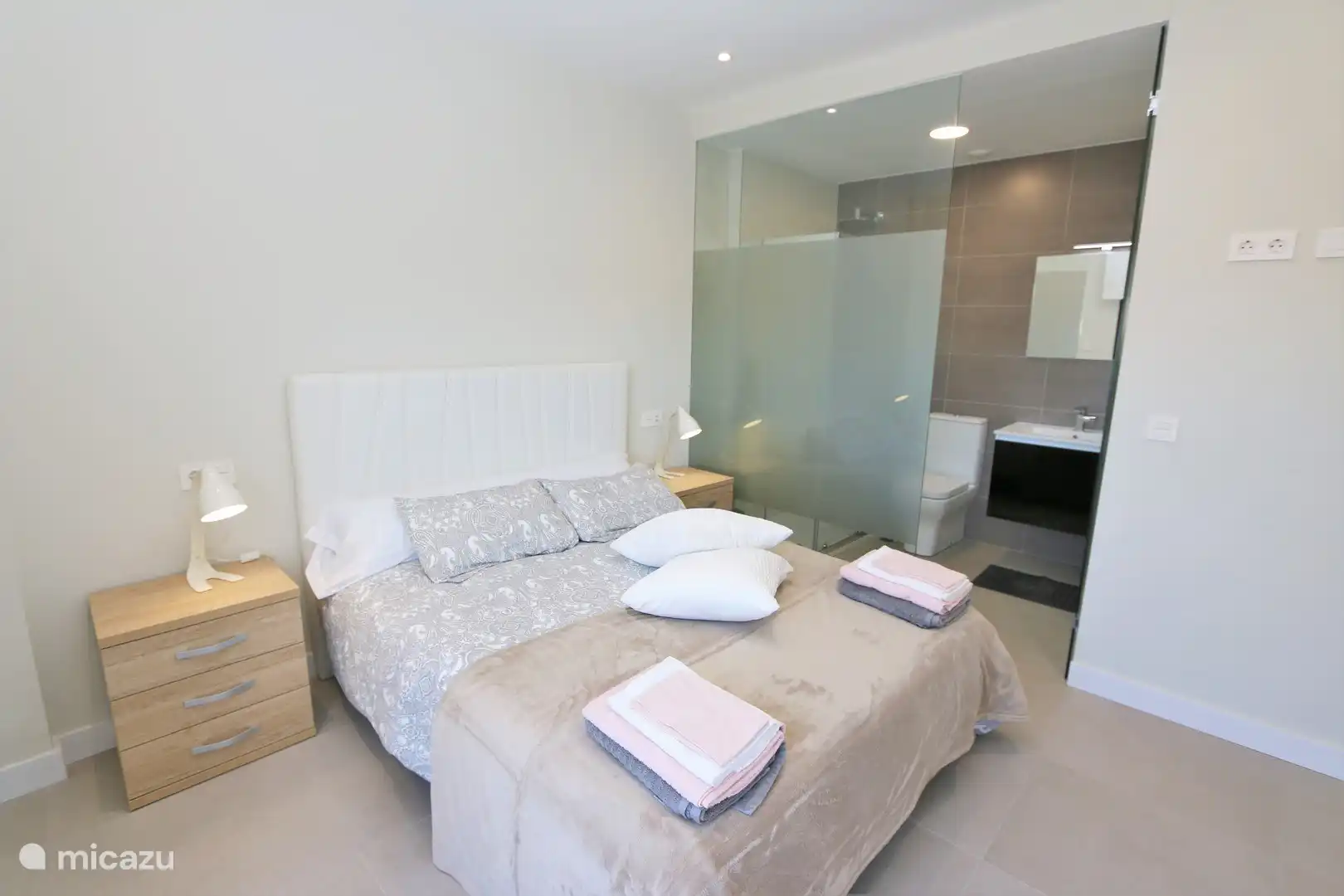 Schlafzimmer mit Doppelbett und Bad