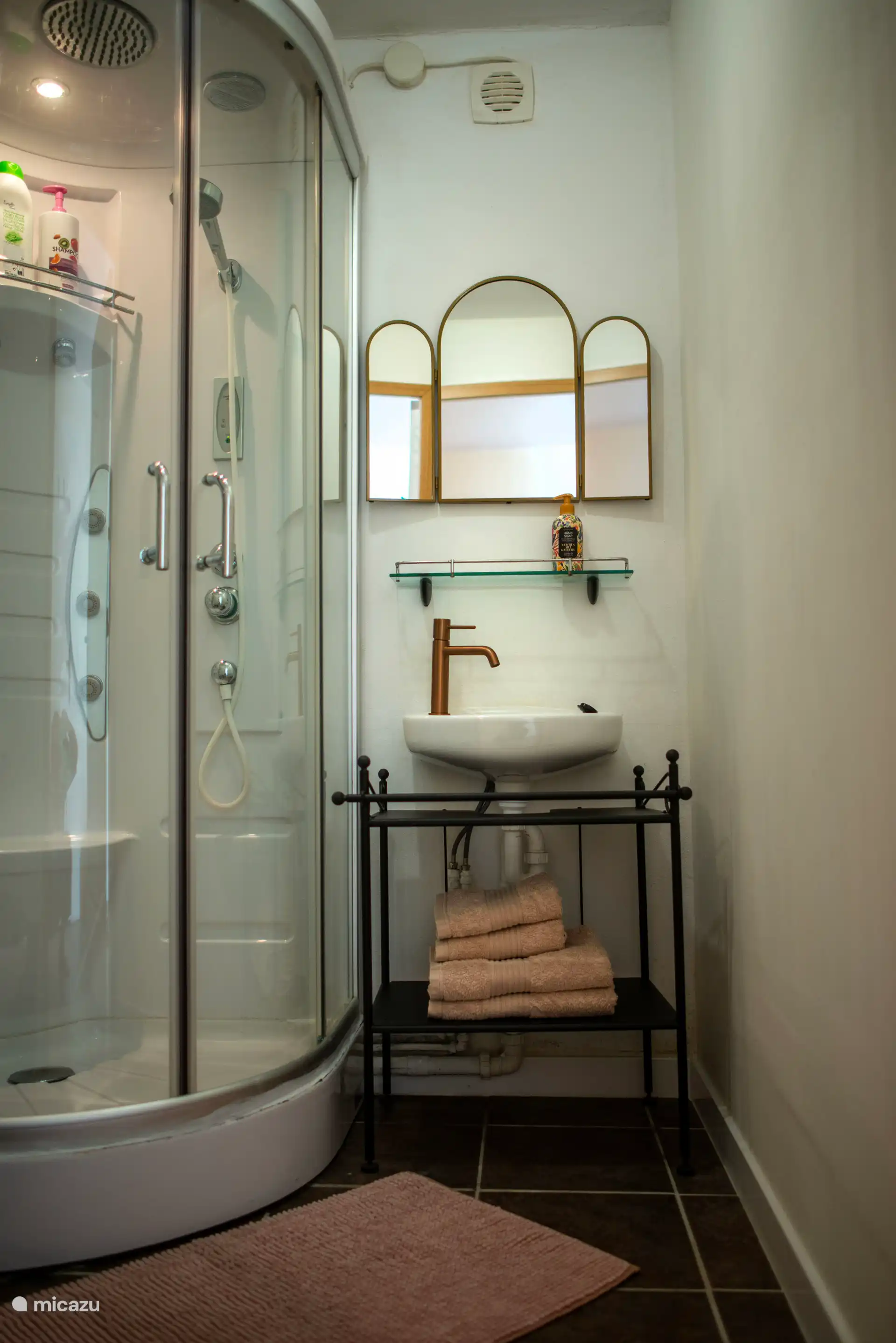Baño completo con cubículo de ducha, lavabo y inodoro