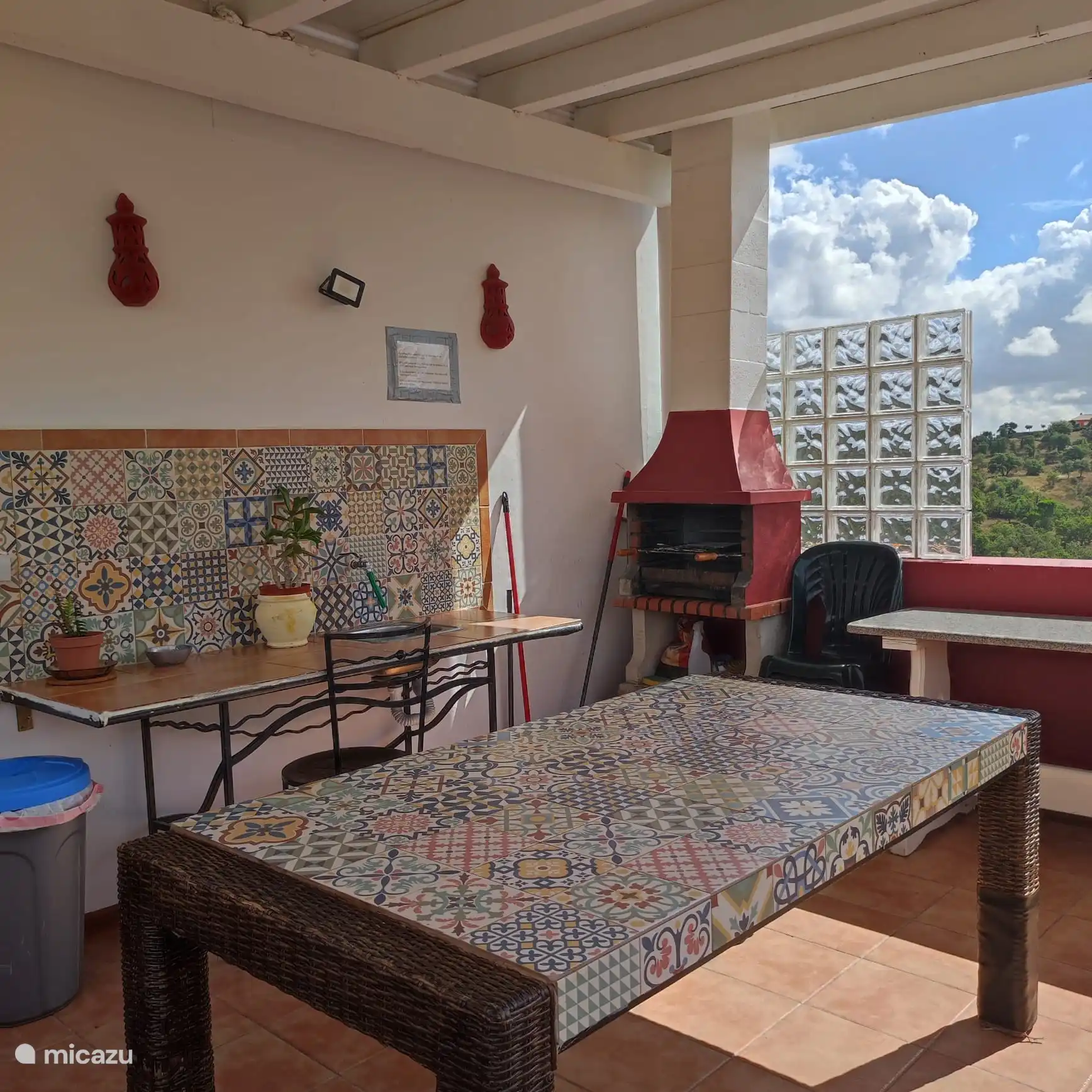 Sur le côté droit de la cuisine, vous avez une porte qui mène à ce balcon avec un barbecue, une table à manger, un évier et une prise électrique que vous pouvez utiliser pour le gril électrique. 