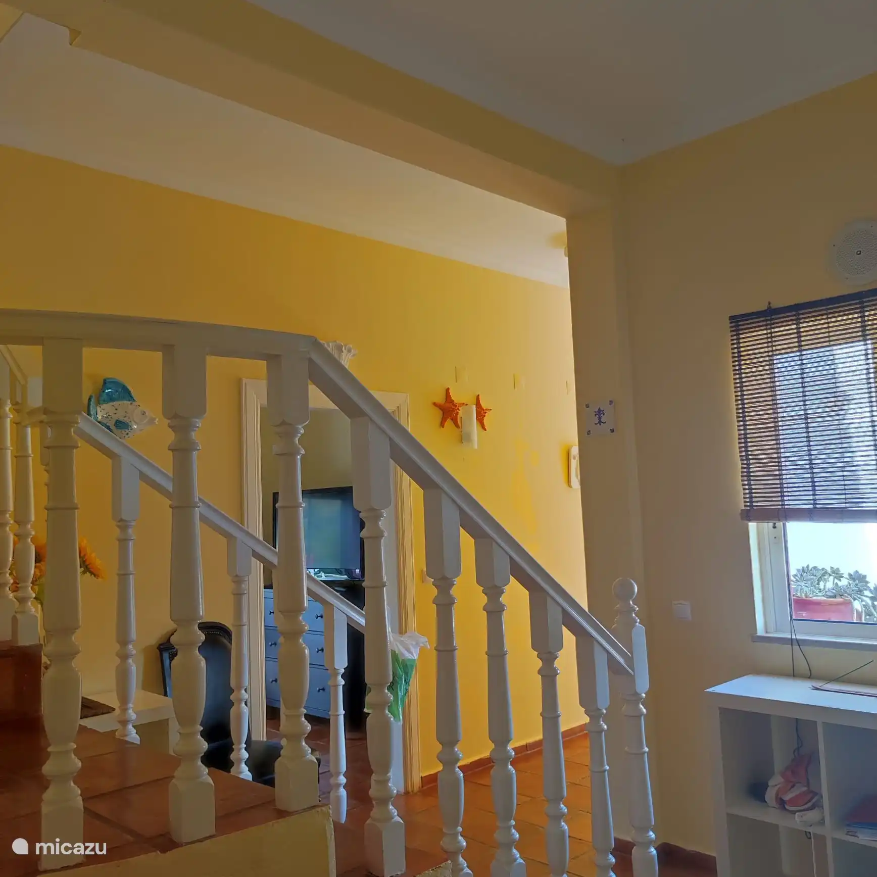 Ici, nous voyons la première entrée une fois que vous avez franchi la porte principale. La porte de la première chambre est à votre droite. Si vous continuez à avancer, cela mènera au couloir principal, ou vous pouvez prendre les escaliers jusqu’au dernier étage. 