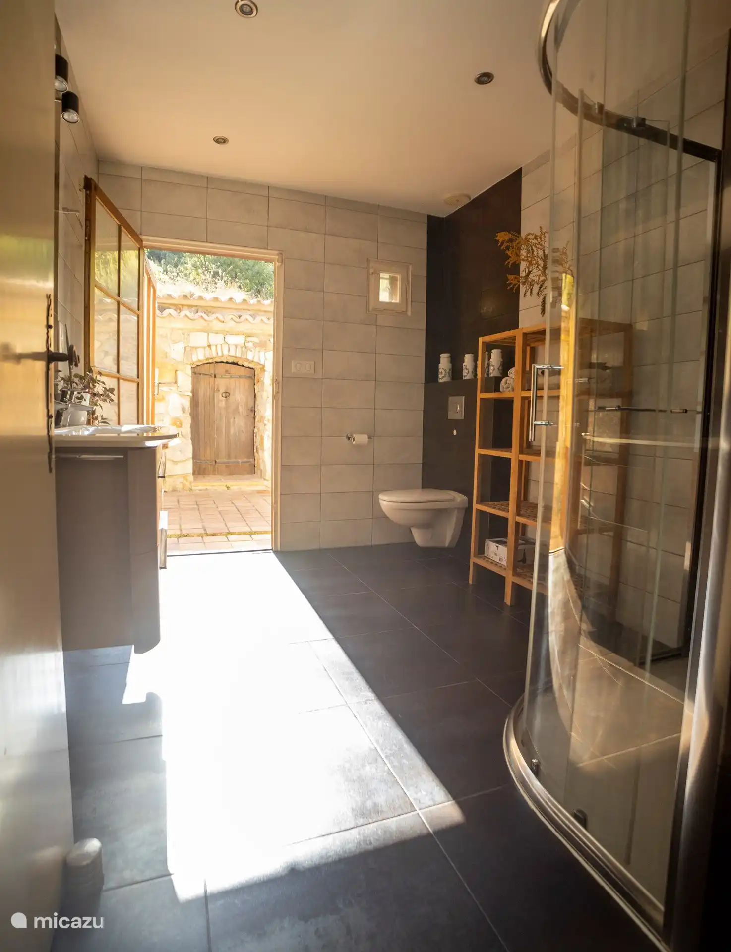 Badezimmer 1 mit WC, Dusche, Doppelwaschbecken und Ausgang nach hinten.