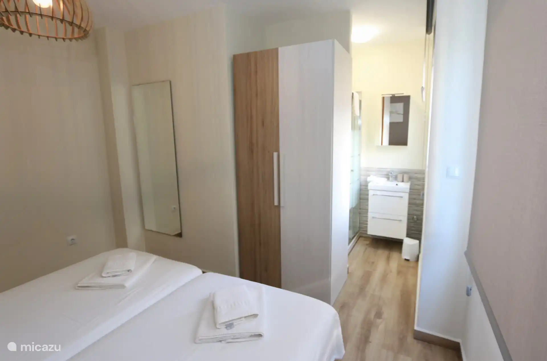 Schlafzimmer mit Doppelbett und Bad