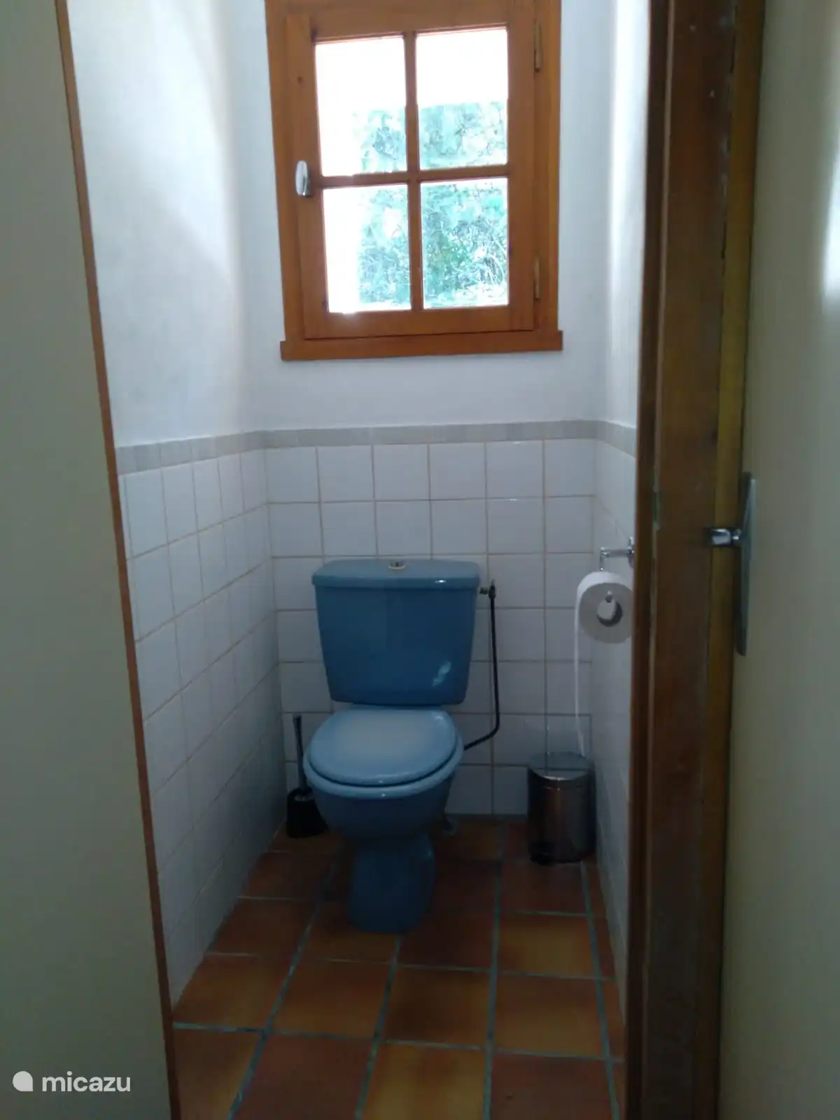 Spacious toilet with tiled walls